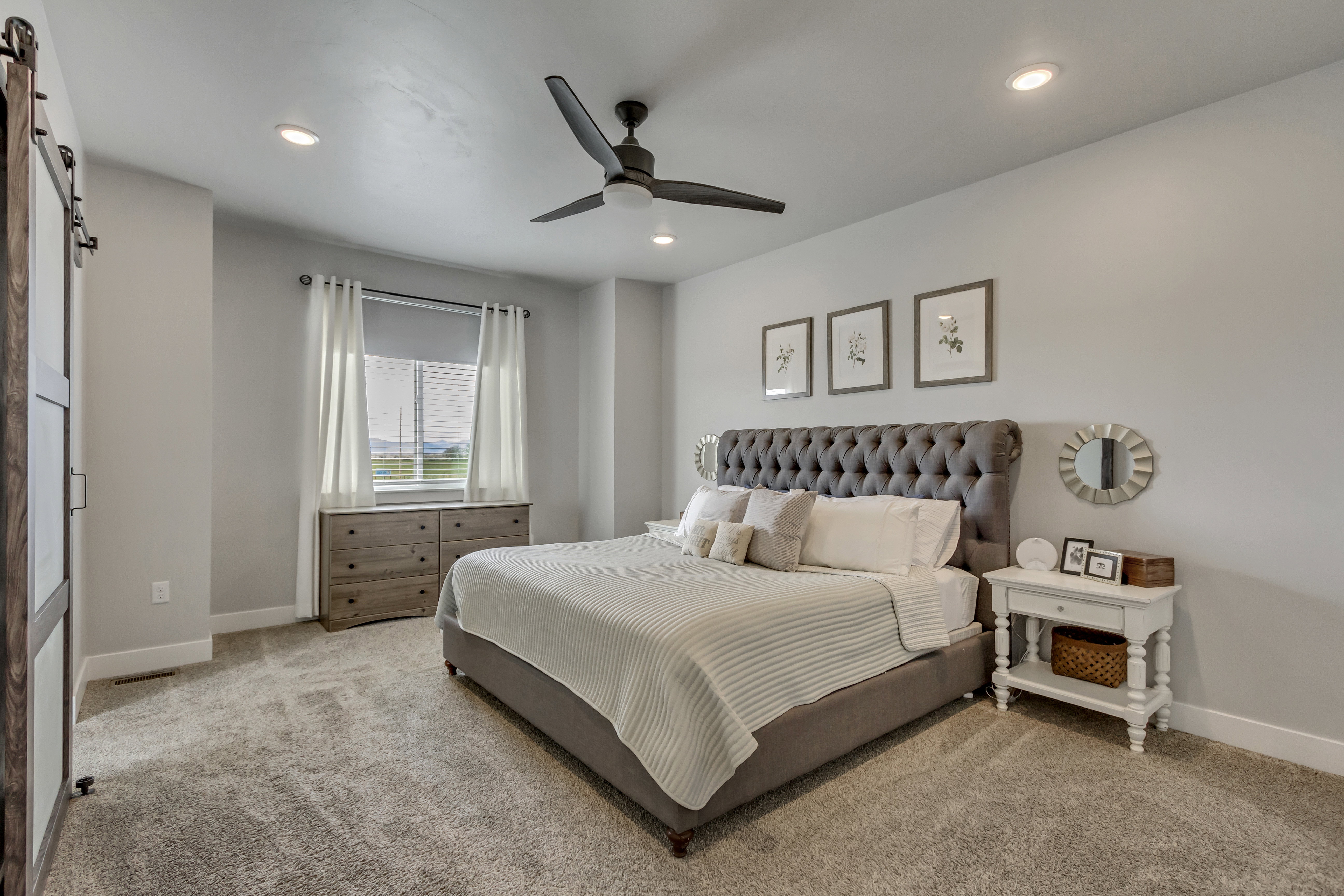 Spacious interior with neutral-toned walls, recessed lighting, and a dark-toned ceiling fan