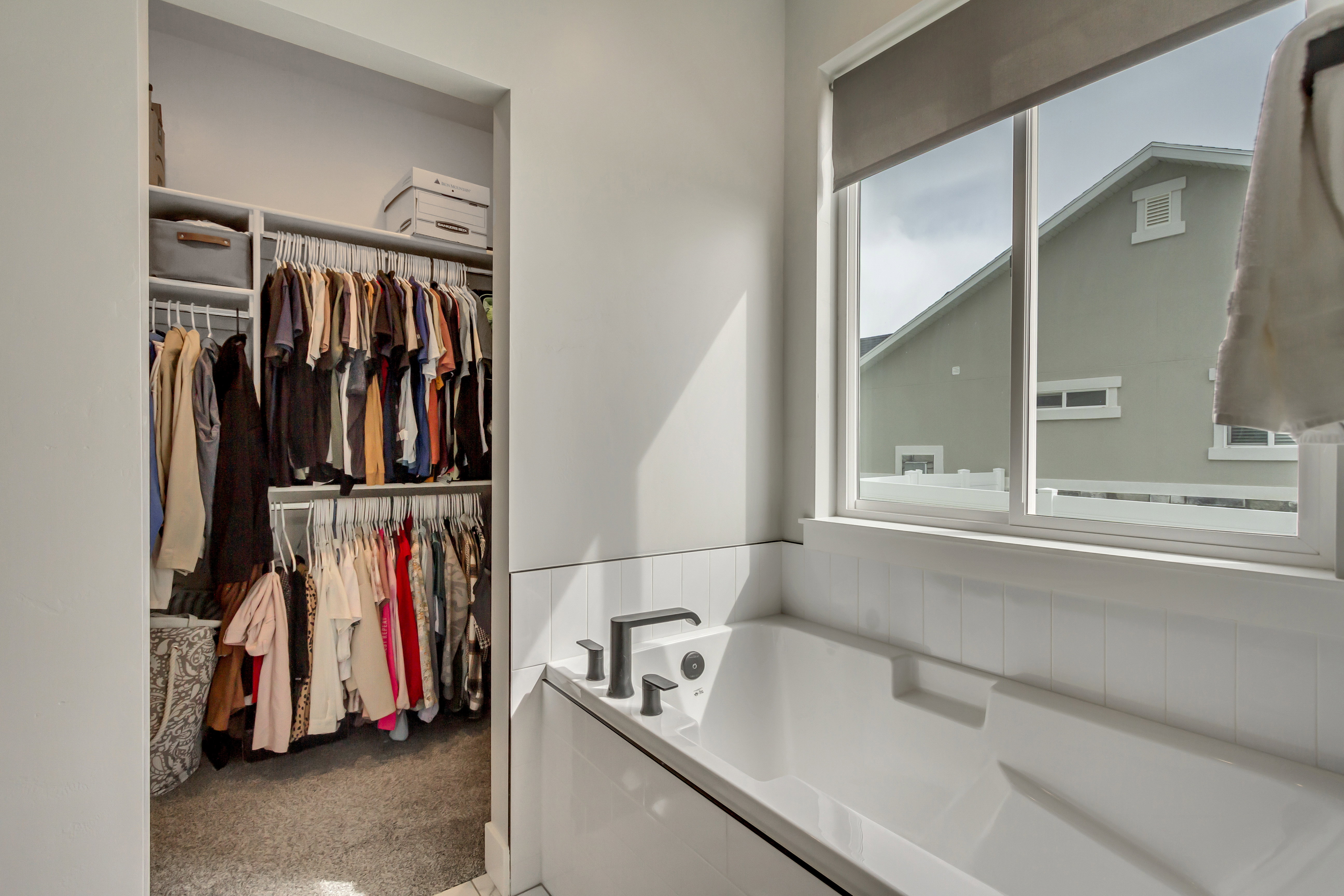Built-in soaking tub with modern black fixtures and a window for natural light