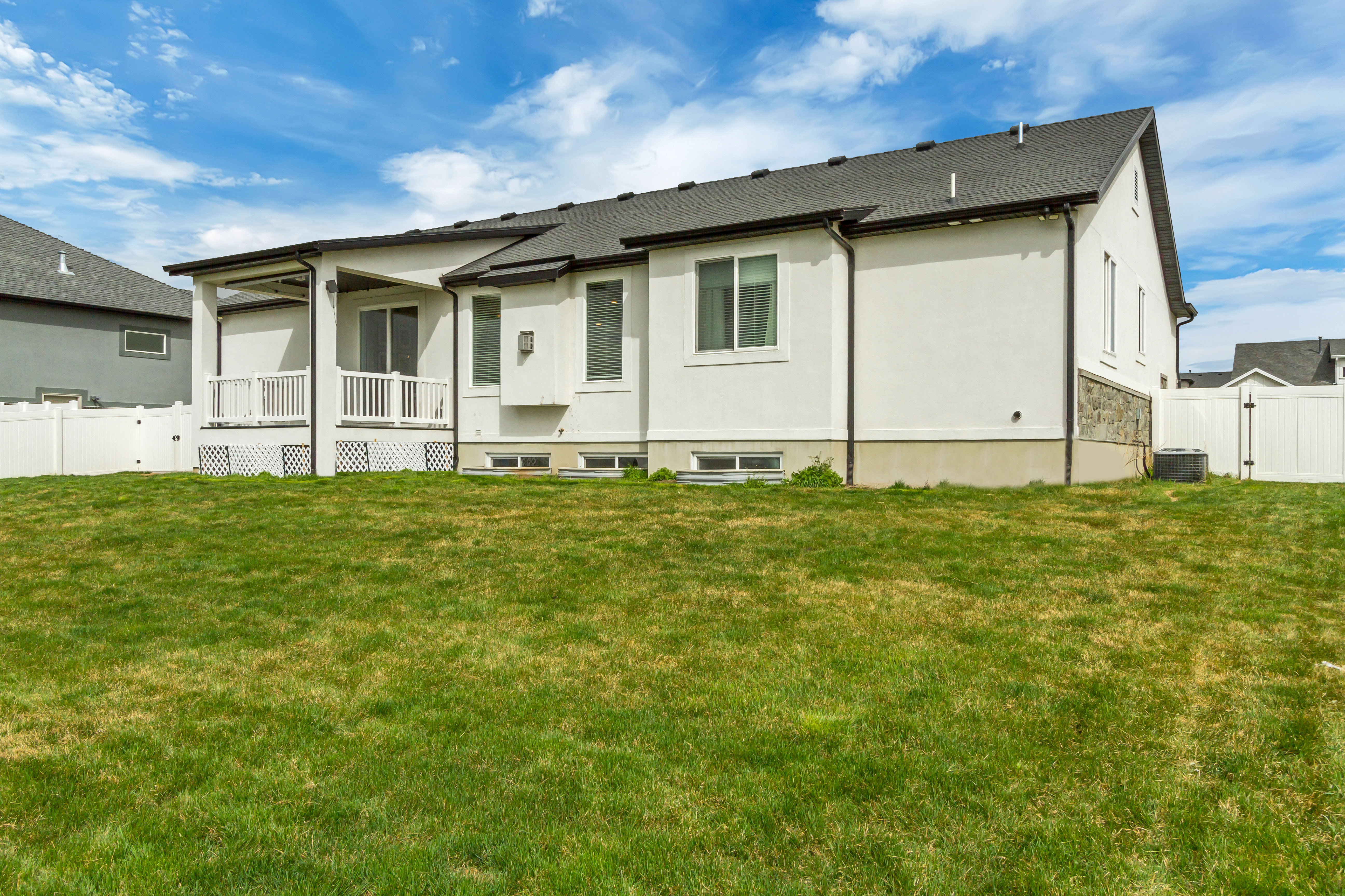 Spacious backyard with a covered patio and white vinyl fencing