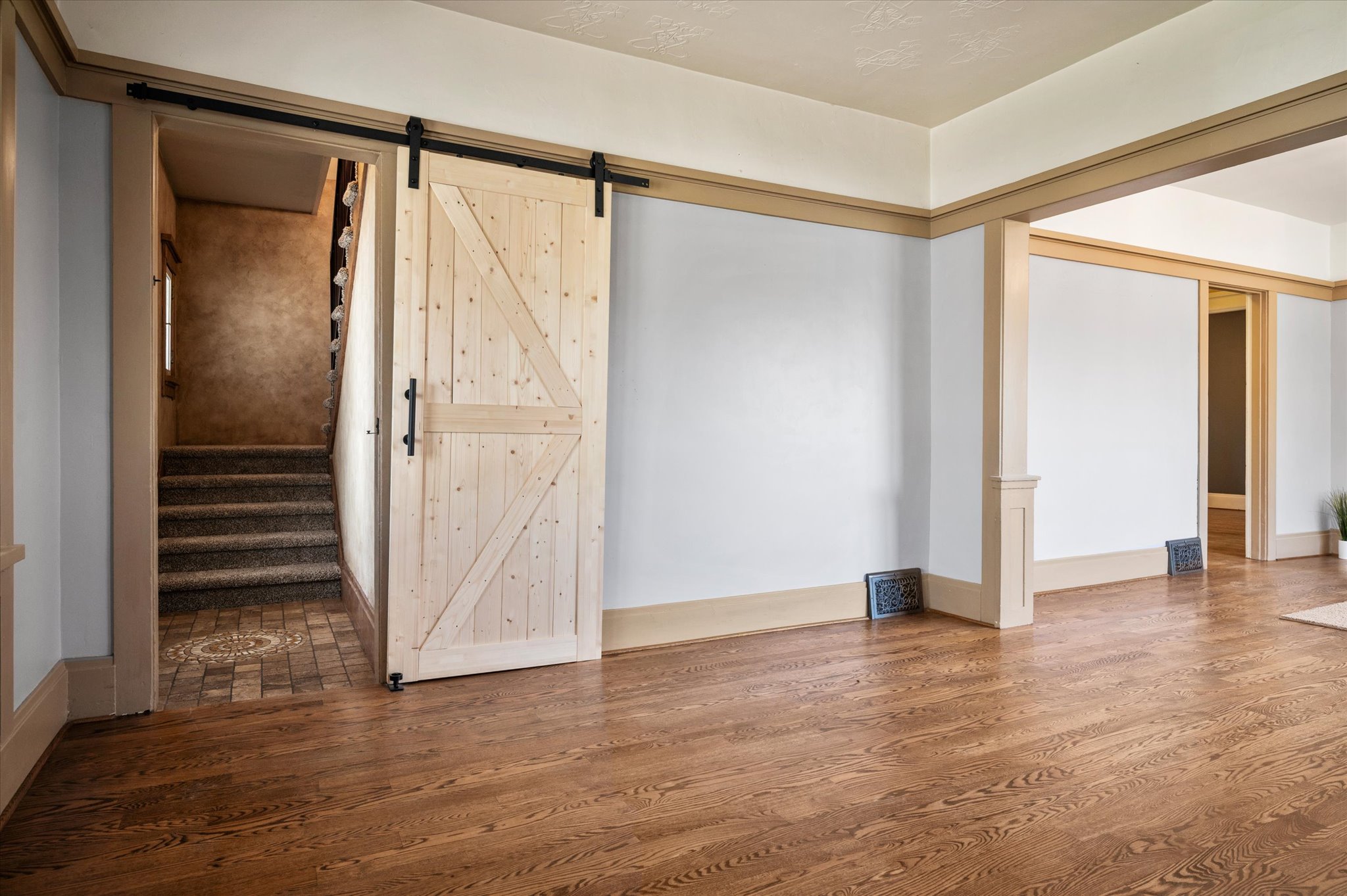 Wide plank wood-finish flooring complements the light-toned walls and trim