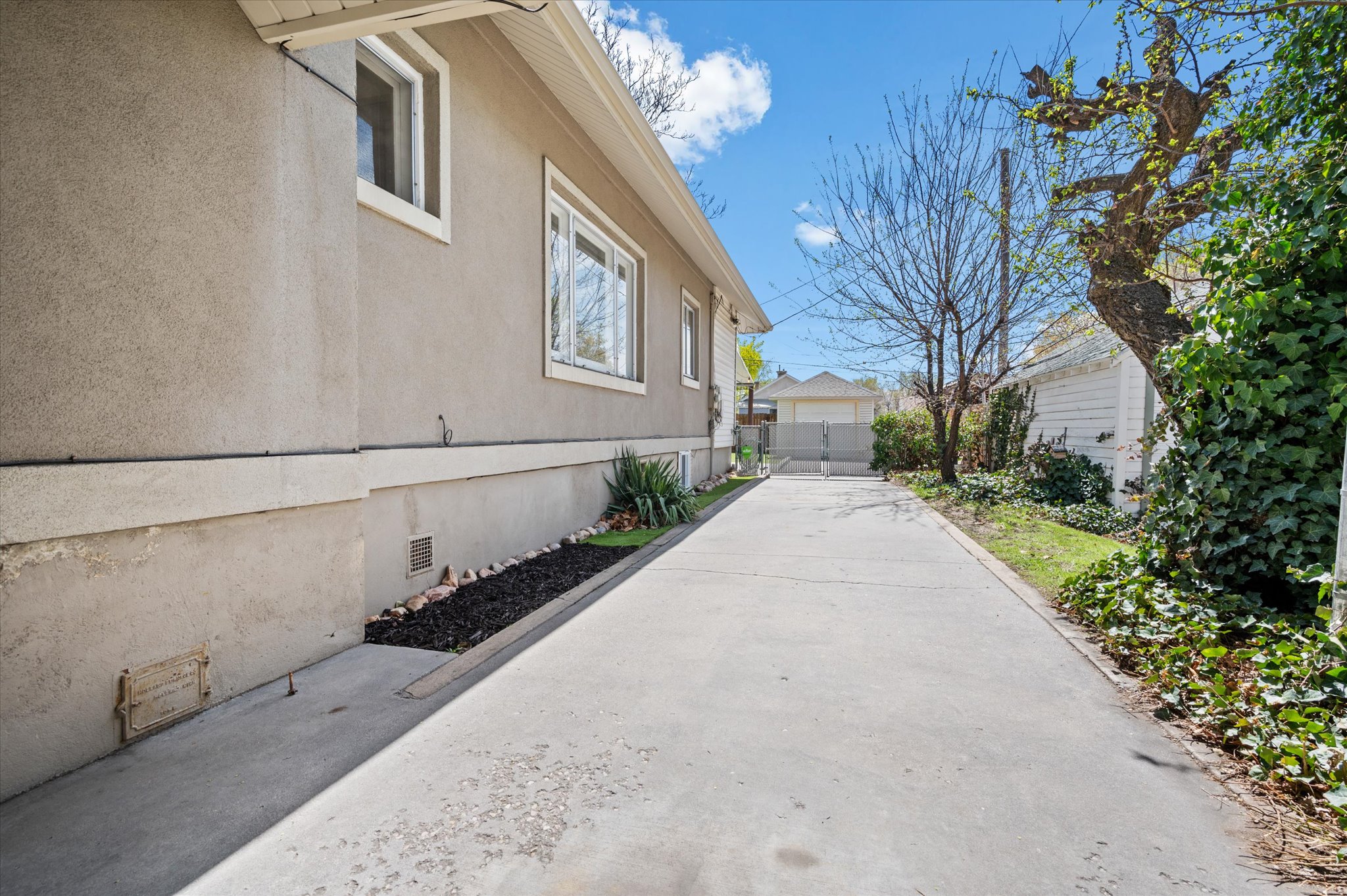 Long concrete driveway providing access to the rear of the property