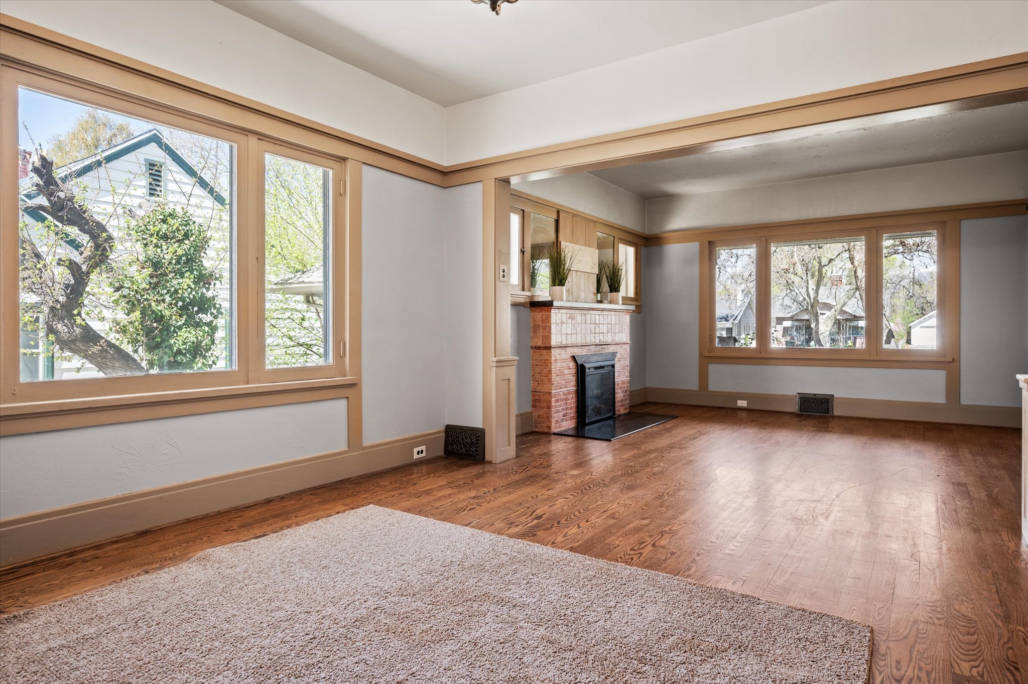 Living space featuring rich wood-finish flooring and extensive natural light from multiple windows