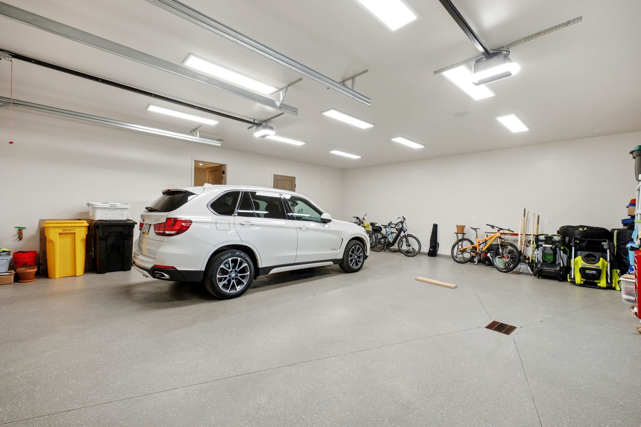 Spacious garage featuring light grey epoxy flooring and multiple recessed lighting fixtures