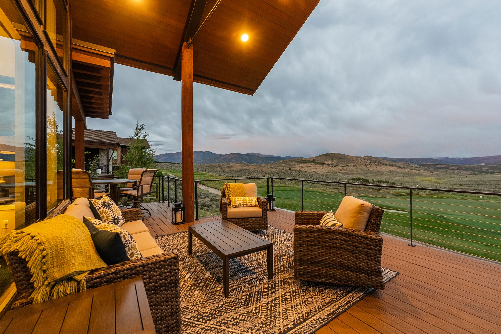 Expansive outdoor deck featuring wood-finish flooring, a covered overhang, and recessed lighting