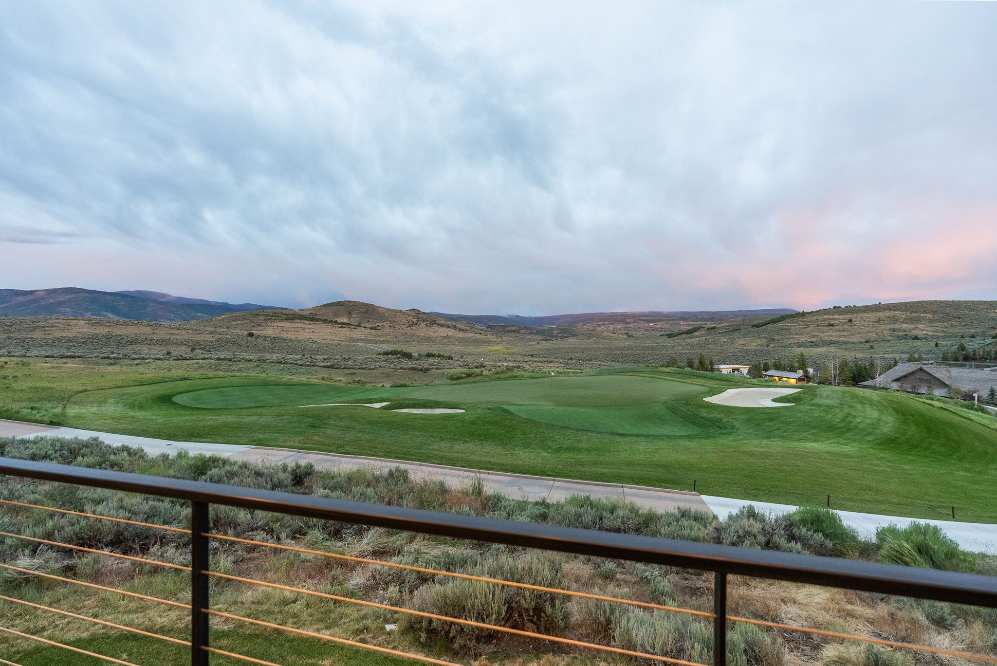 Cable railing balcony overlooking a golf course green with a sand trap