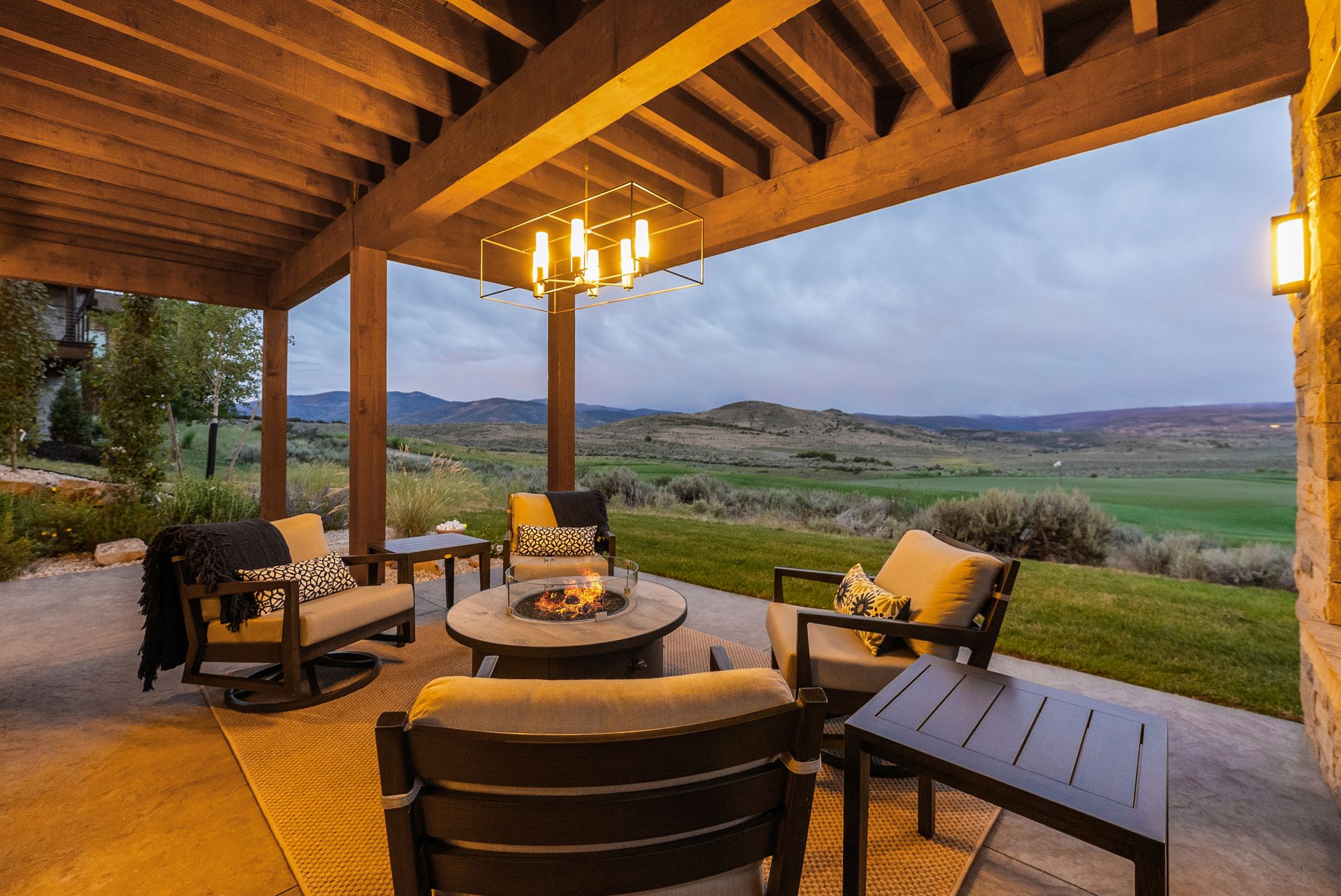 Covered patio featuring a wood-beam ceiling, stone accent wall, and recessed lighting