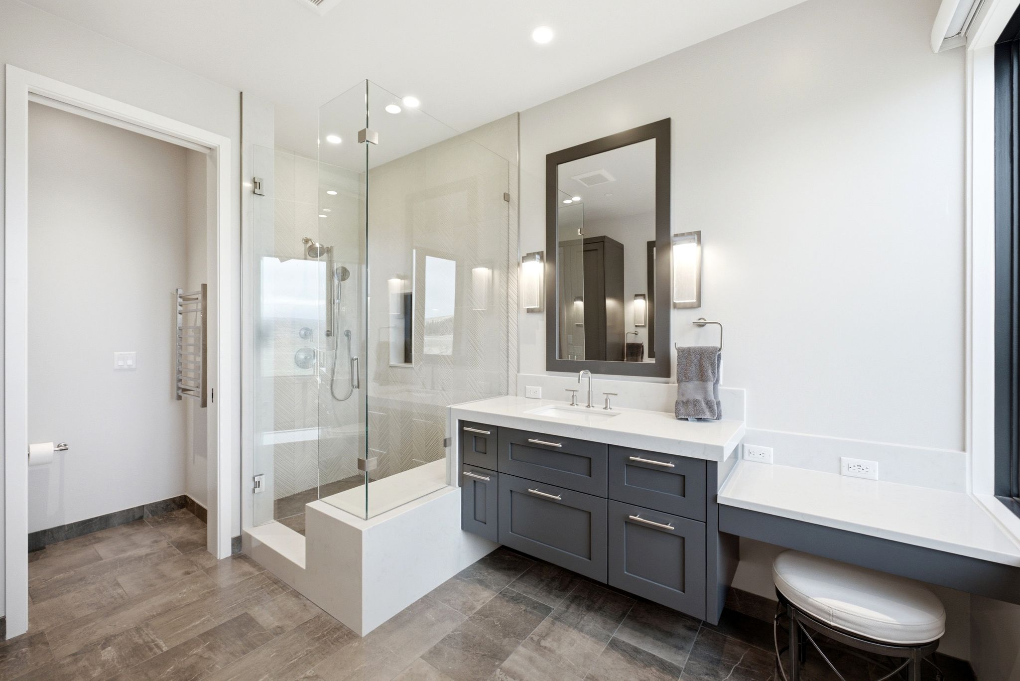 Modern bathroom featuring a frameless glass shower enclosure with a built-in bench