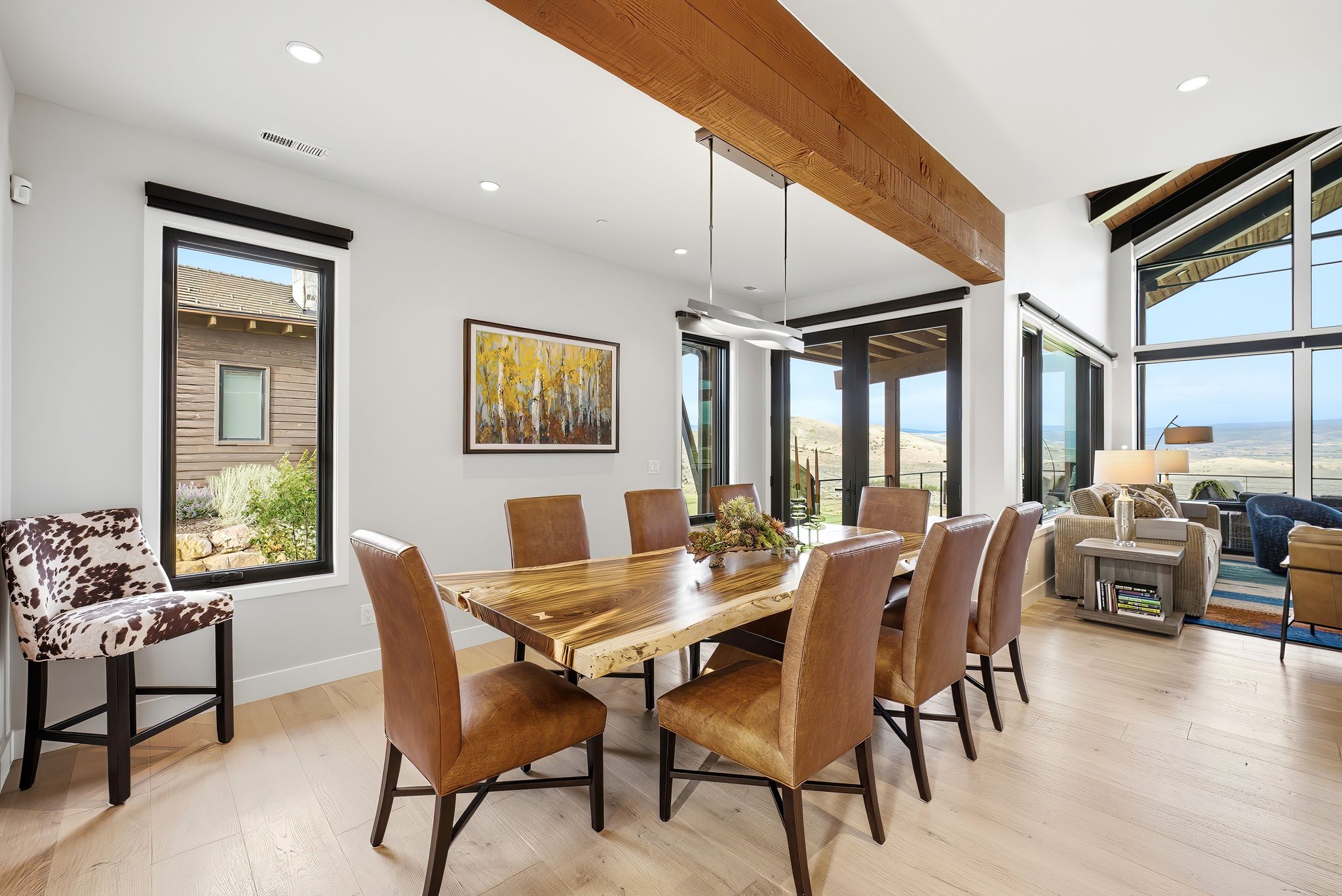 Open-concept living area featuring light wood-finish flooring, a wood beam ceiling accent, and recessed lighting