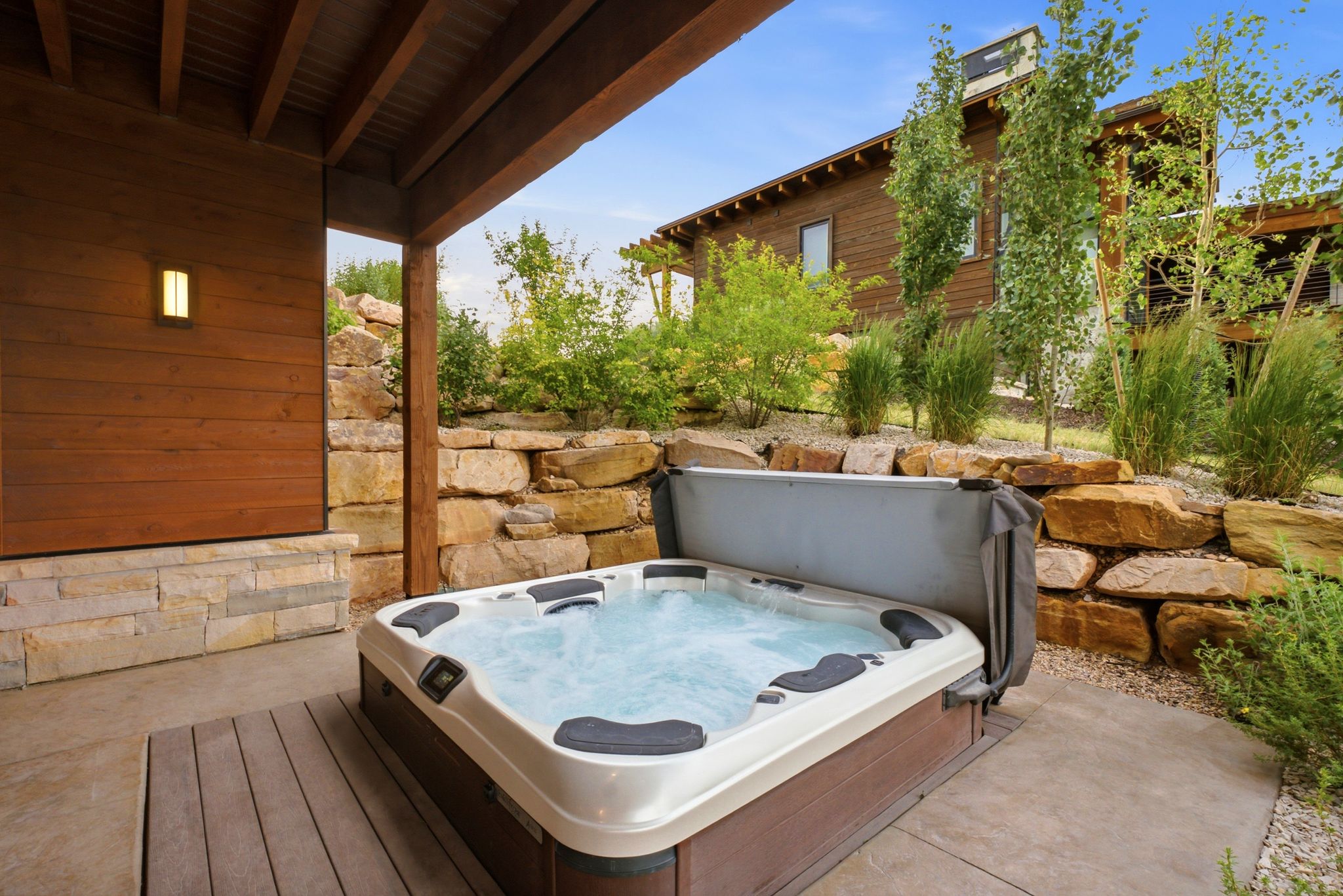 Outdoor spa tub positioned on a concrete patio with wood-finish decking