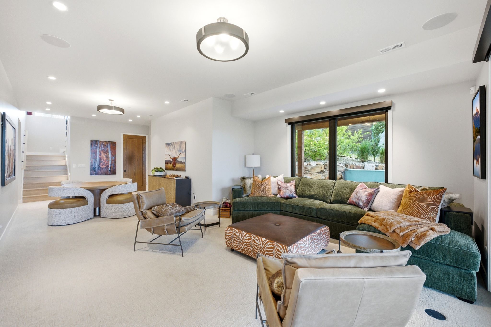 Spacious living area featuring neutral carpeting, recessed lighting, large picture windows, and a built-in staircase