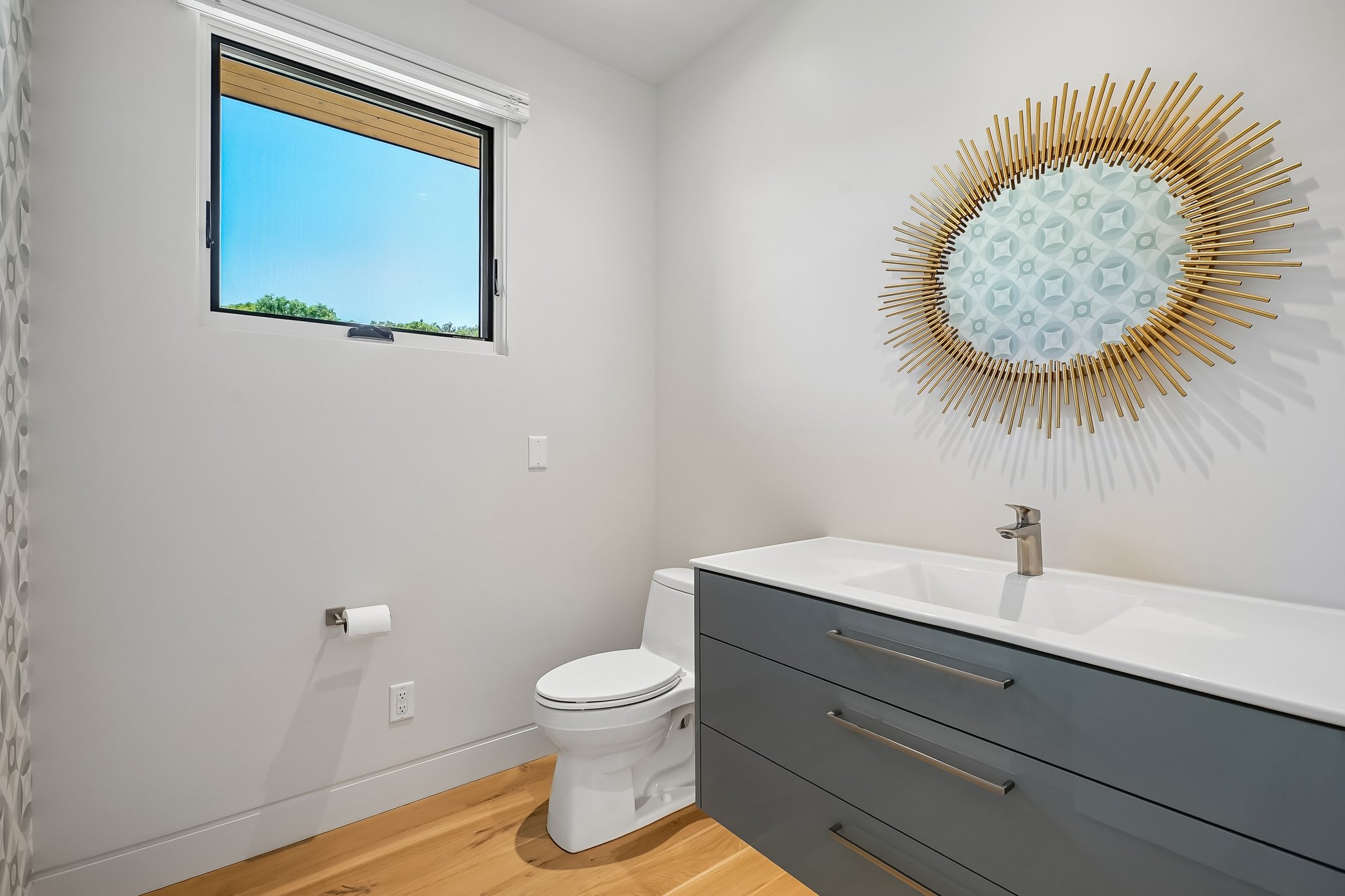 Floating vanity with an integrated sink and brushed metal faucet