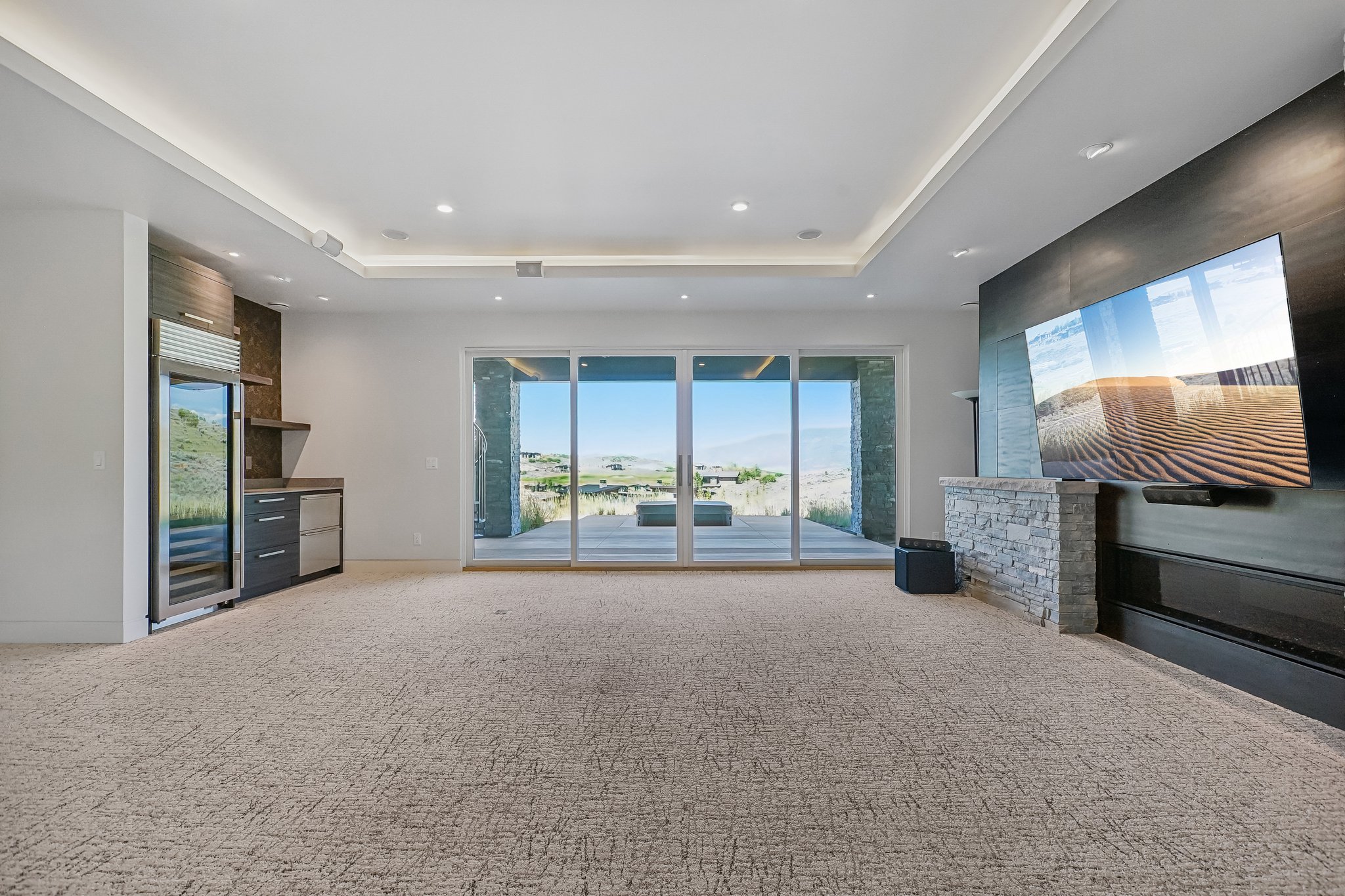 Expansive room featuring sliding glass doors to the exterior, recessed lighting, and tray ceiling