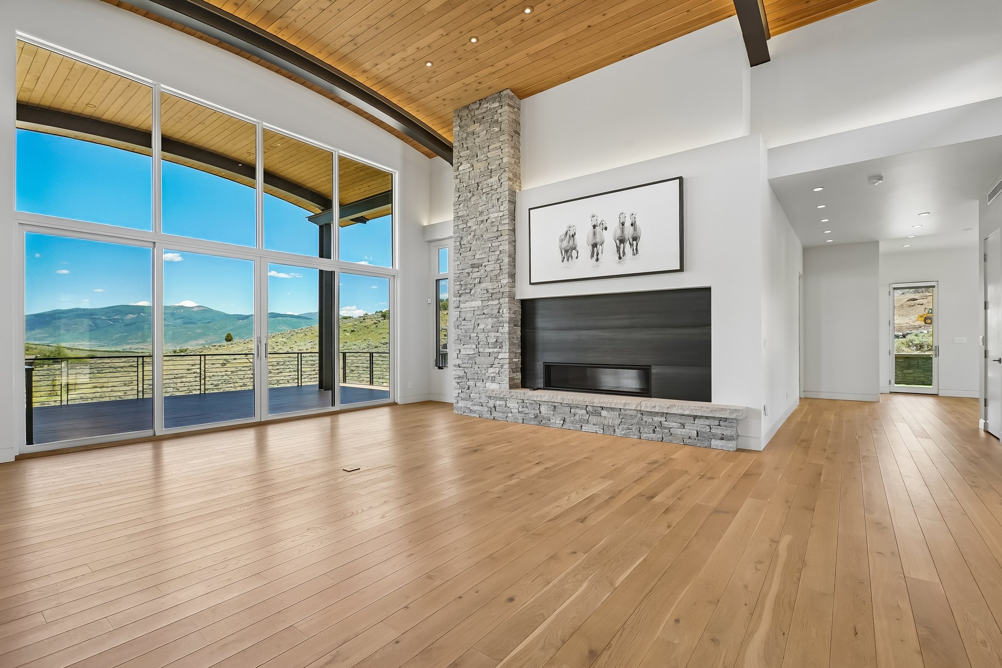 Expansive window wall with sliding glass doors opening to a deck