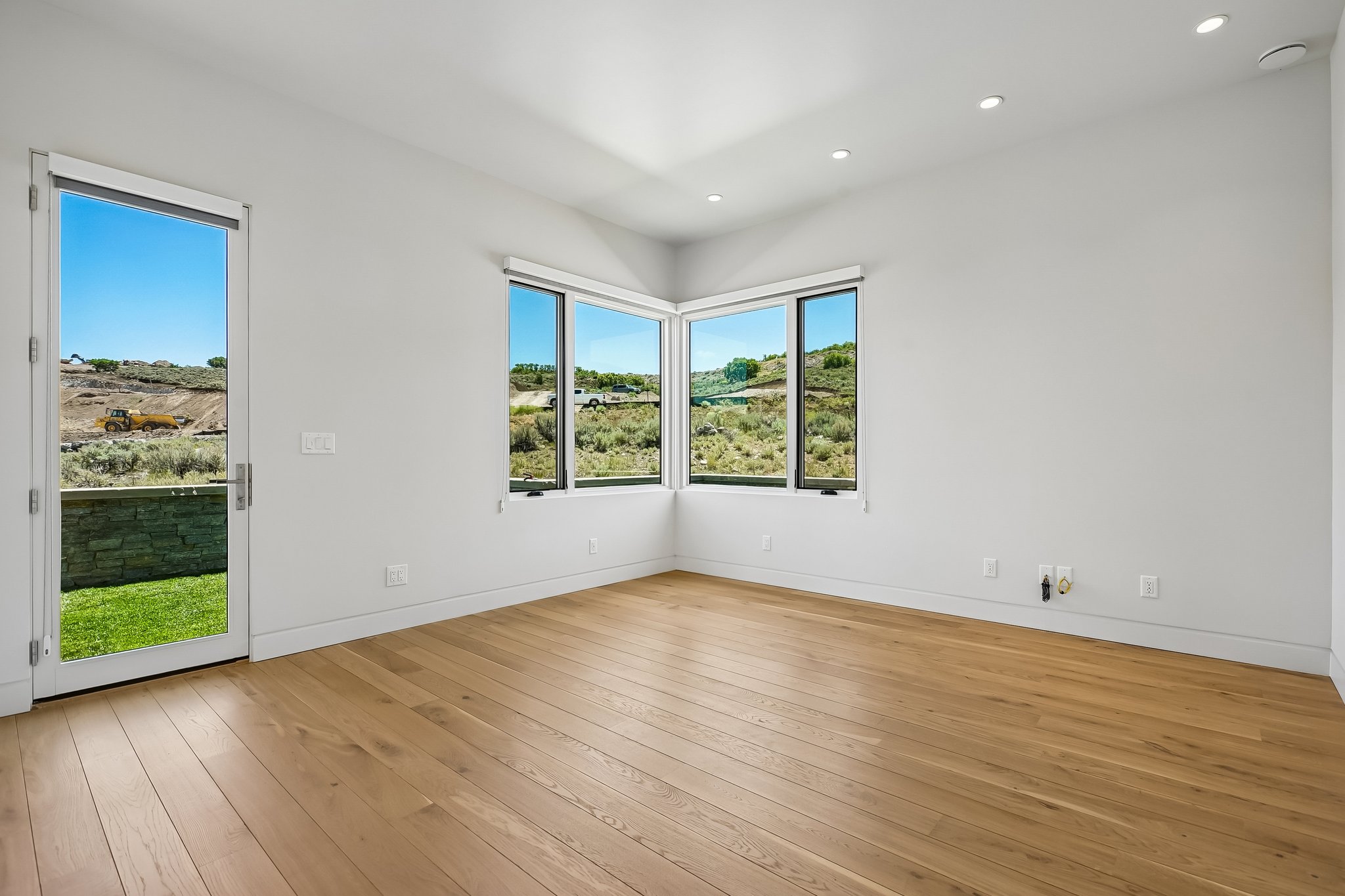 Bright room featuring wood-finish flooring, recessed lighting, and expansive windows