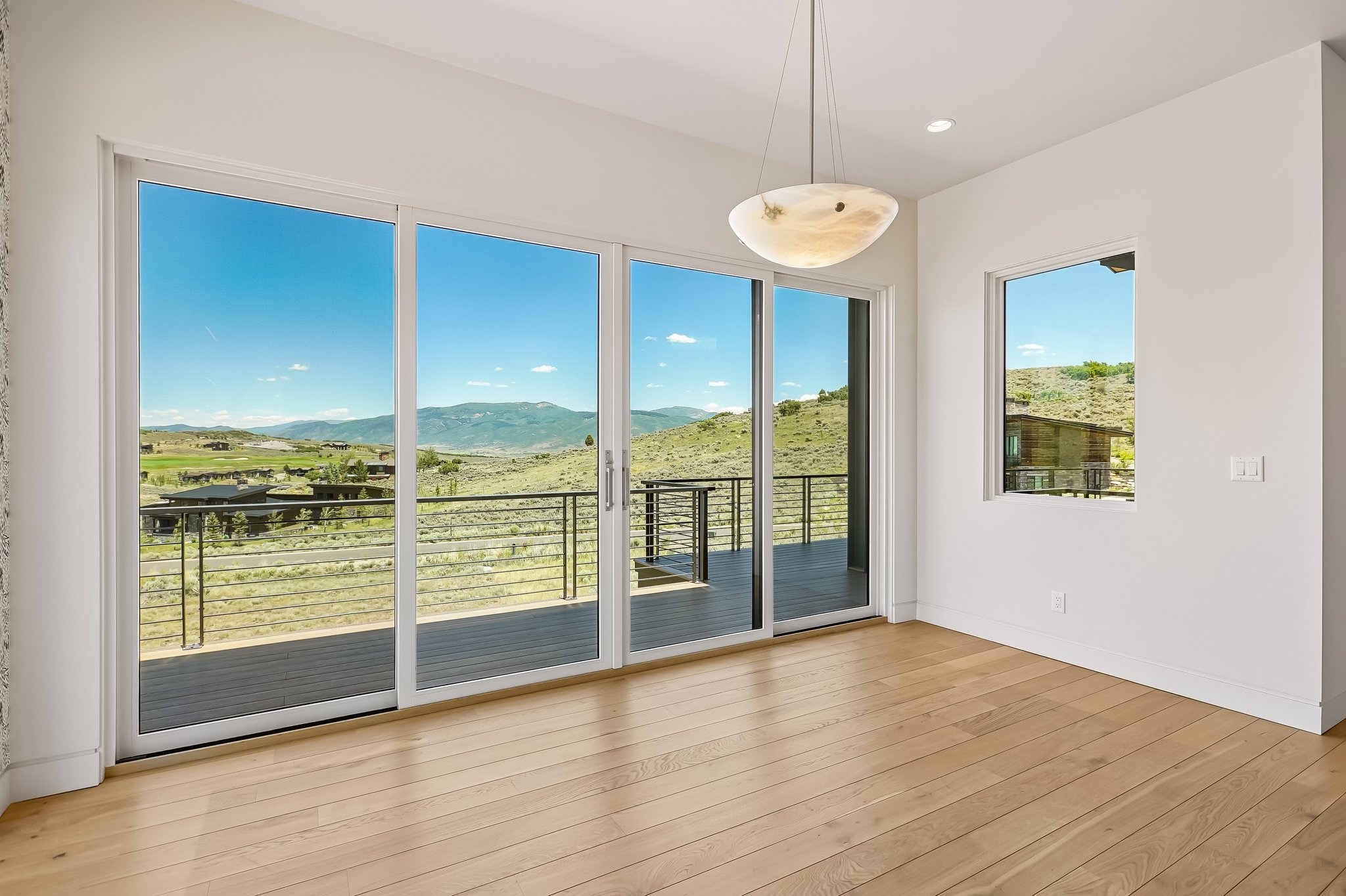 Spacious room featuring light wood-finish flooring and white walls