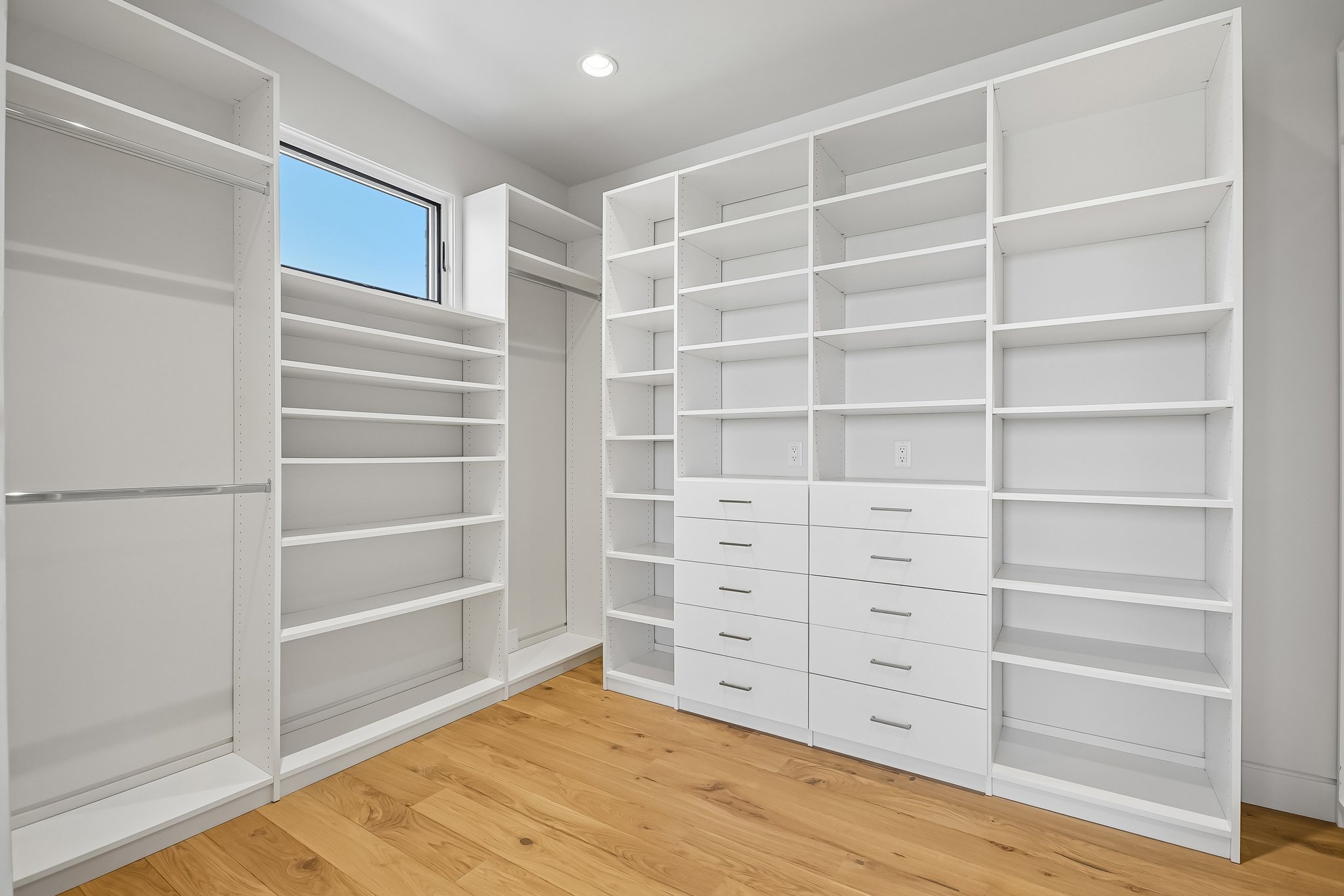 Custom closet system featuring extensive shelving, multiple hanging rods, and built-in drawers