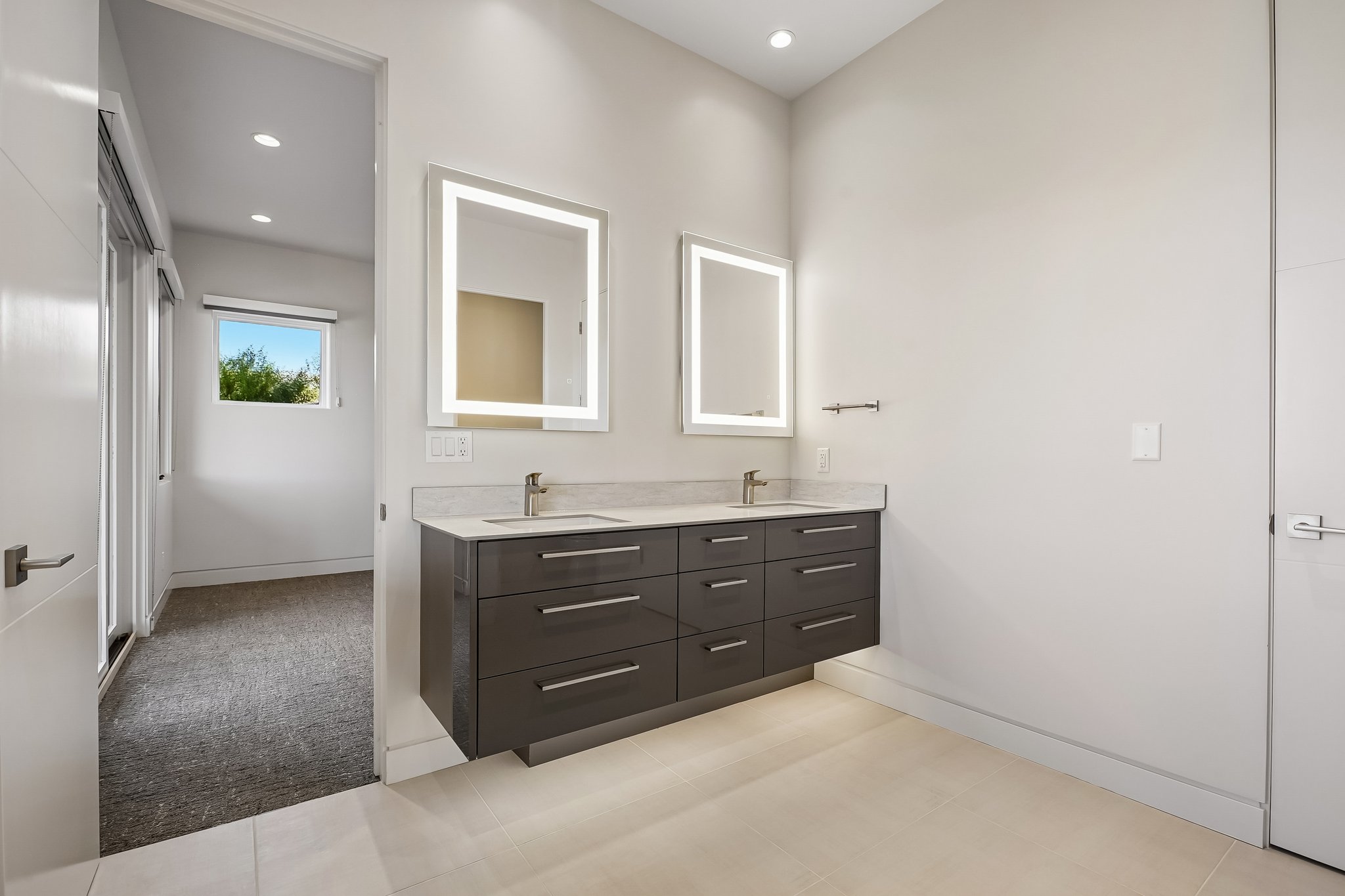 Floating double vanity with a light-toned countertop, two integrated sinks, and contemporary wall-mounted faucets