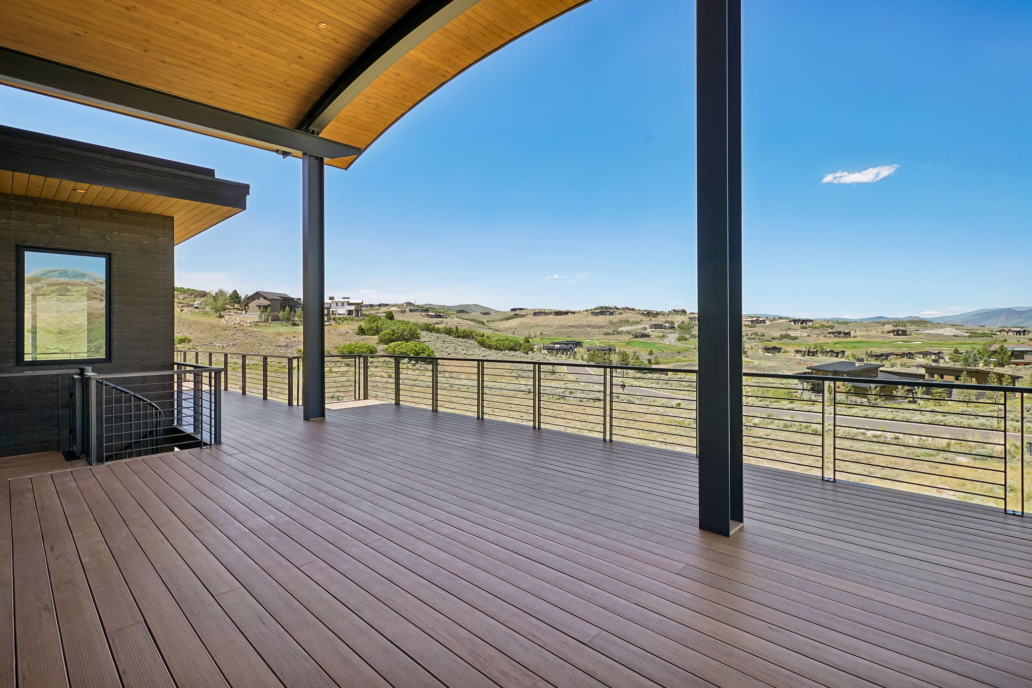 Expansive outdoor deck featuring wood-look flooring and cable railing