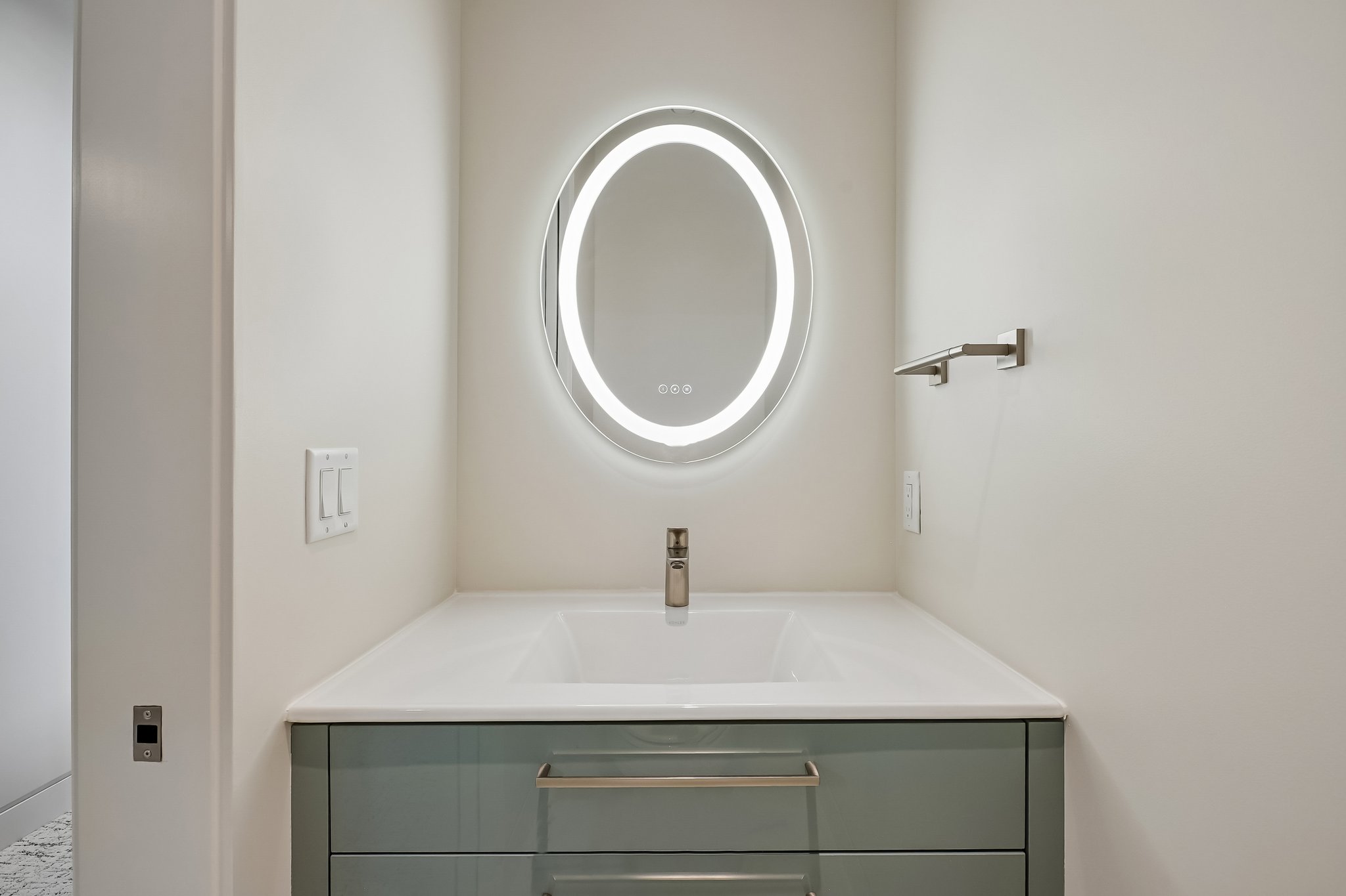 Modern vanity featuring a rectangular integrated sink, light countertop, and a sleek brushed nickel faucet