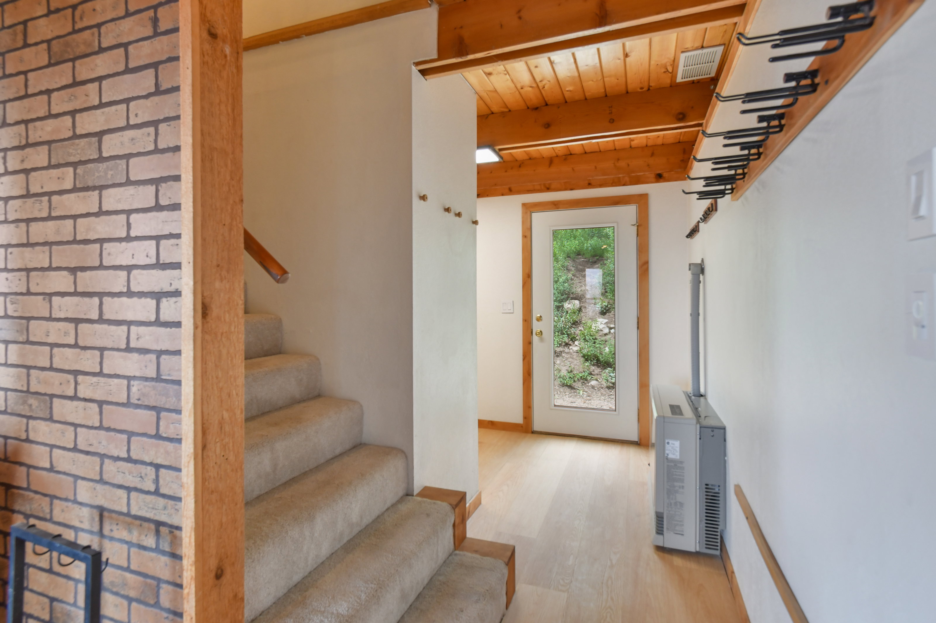 Entryway featuring a glass-paneled door, natural wood-finish flooring, and a natural wood-plank ceiling