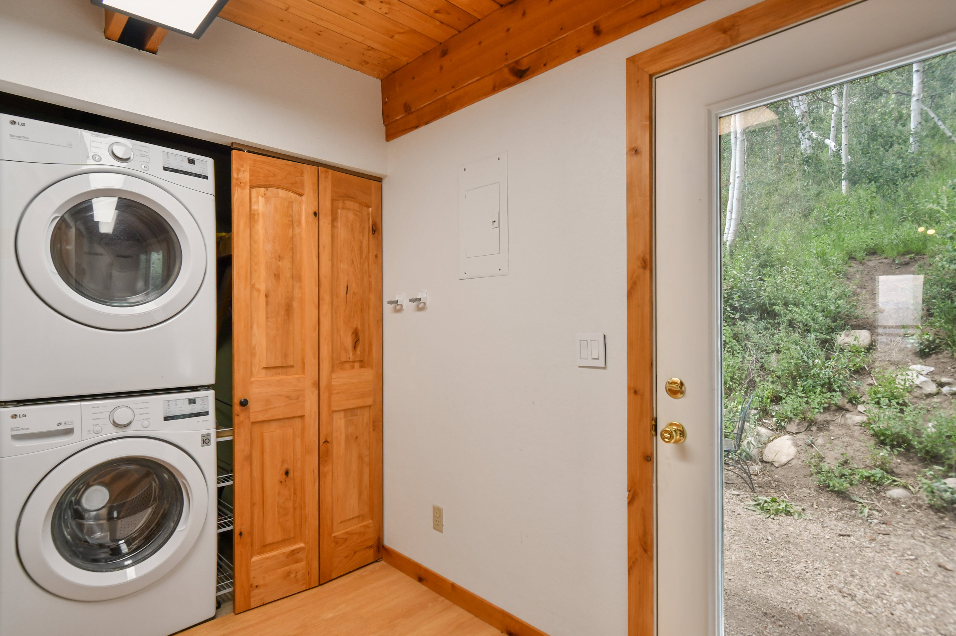 Dedicated laundry area featuring stacked front-load washer and dryer units