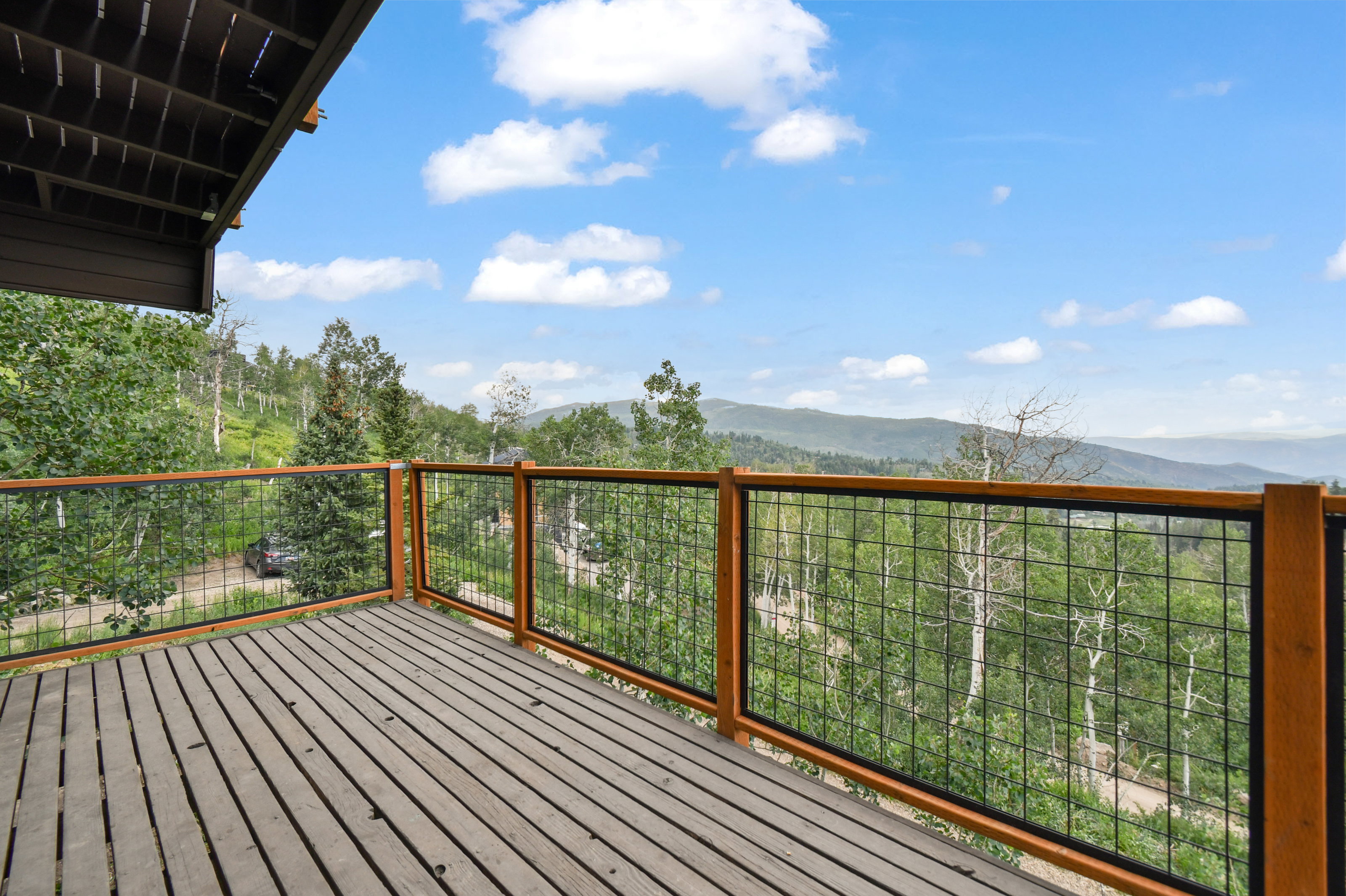 Expansive wooden deck featuring horizontal planking and a modern grid railing system