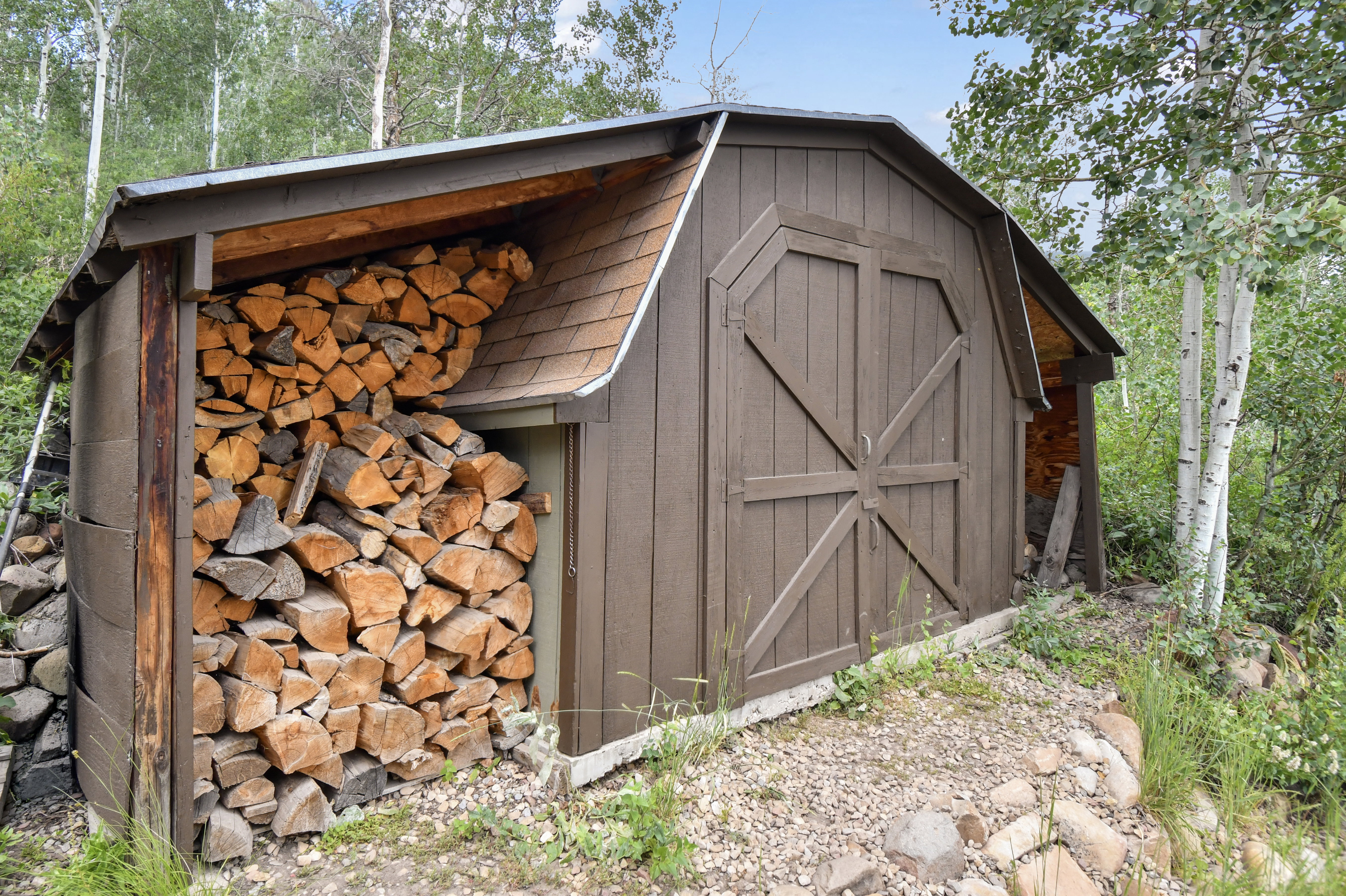 Barn-style shed featuring brown siding and a concrete foundation