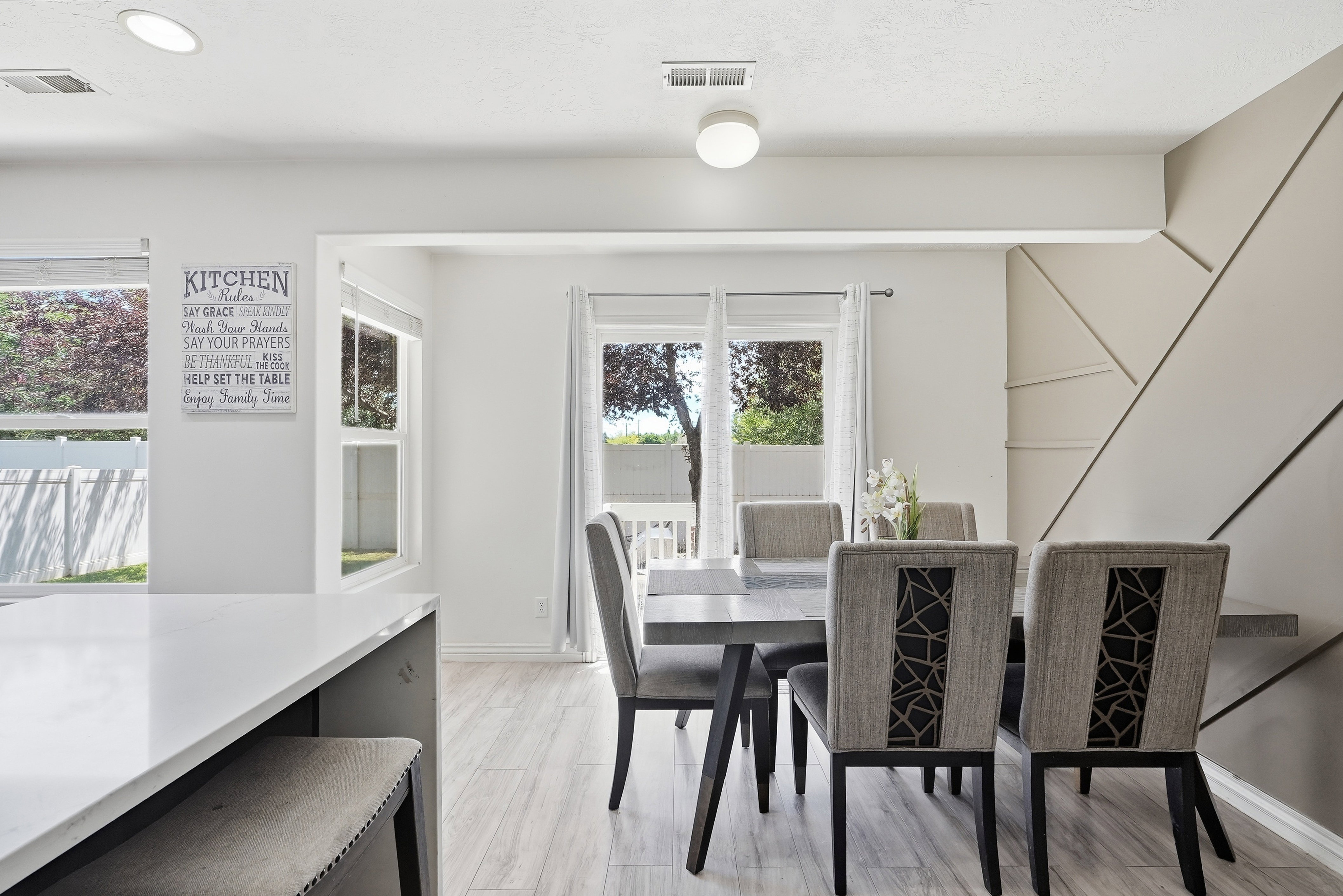 Dining area featuring wood-finish flooring, a contemporary accent wall, recessed lighting, and ample natural light from multiple windows
