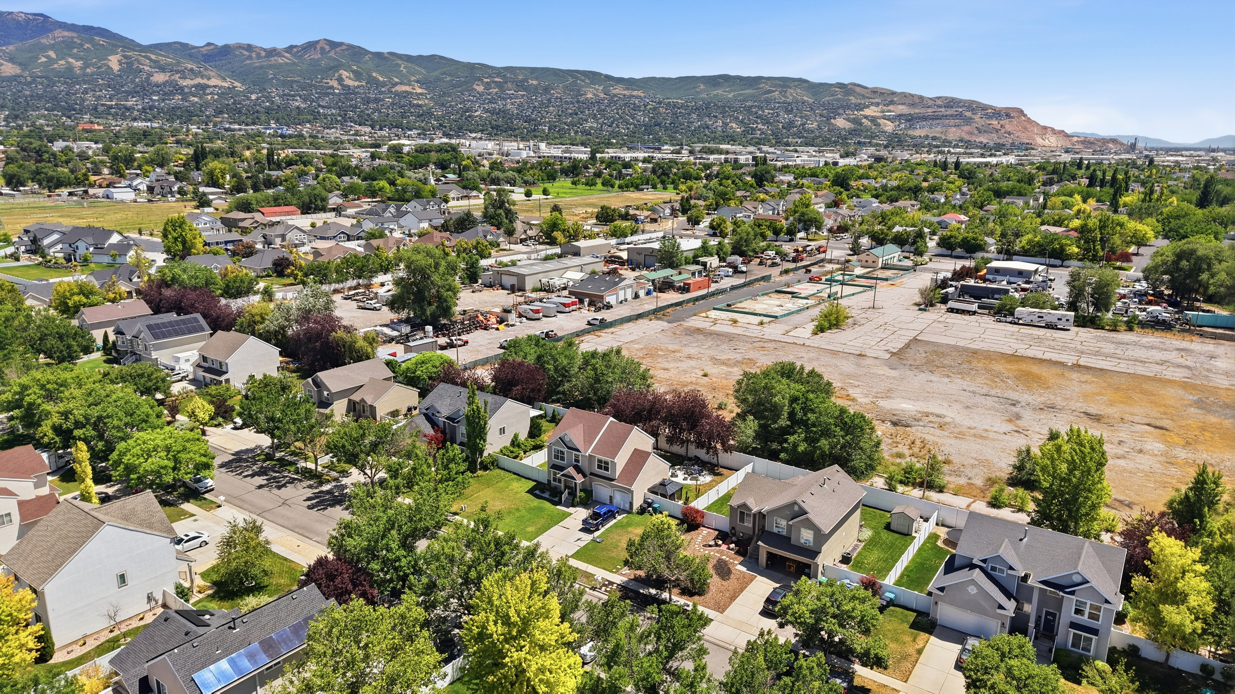 Residential neighborhood with mature trees and mountain backdrop