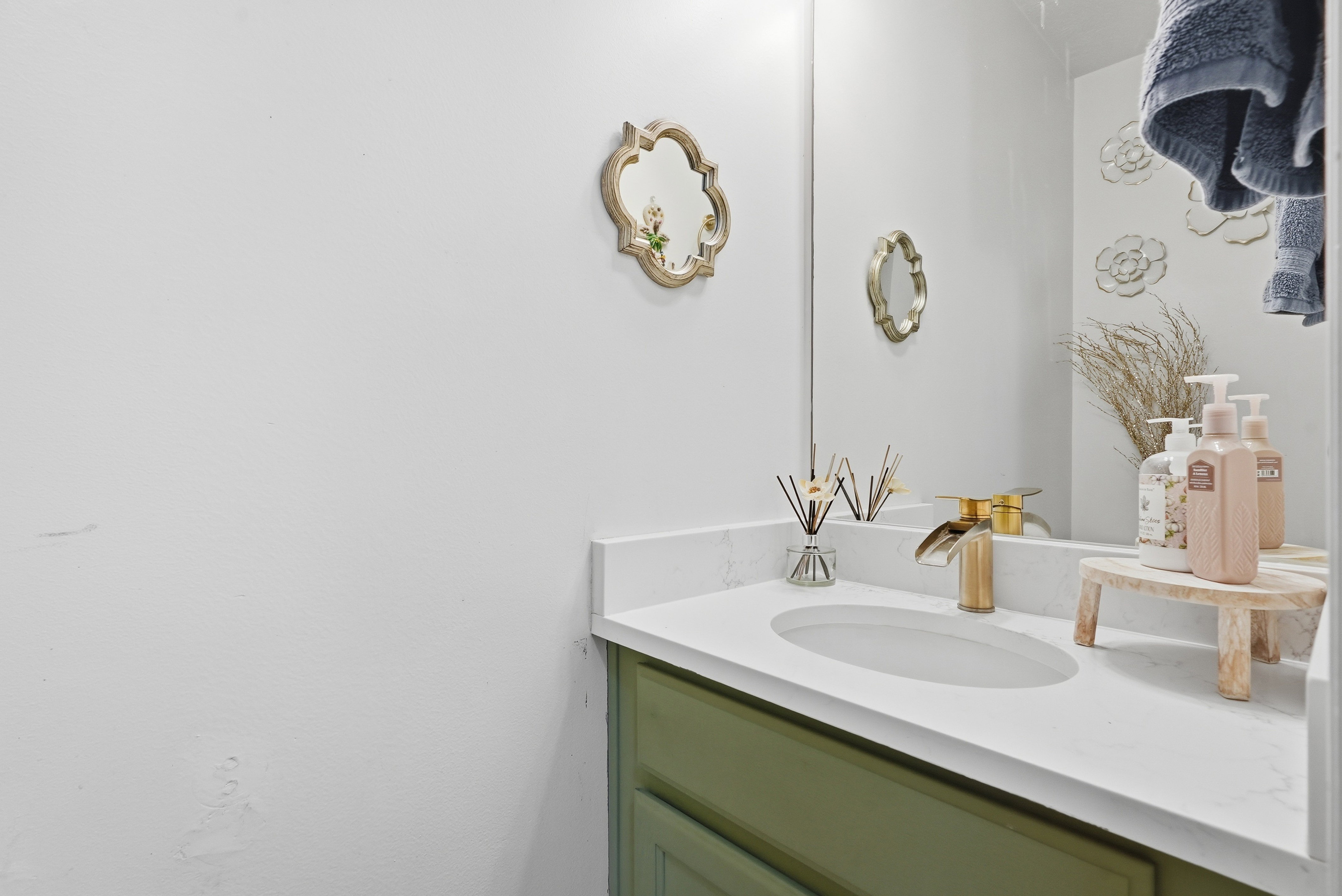 White countertop with integrated sink and gold-tone waterfall faucet