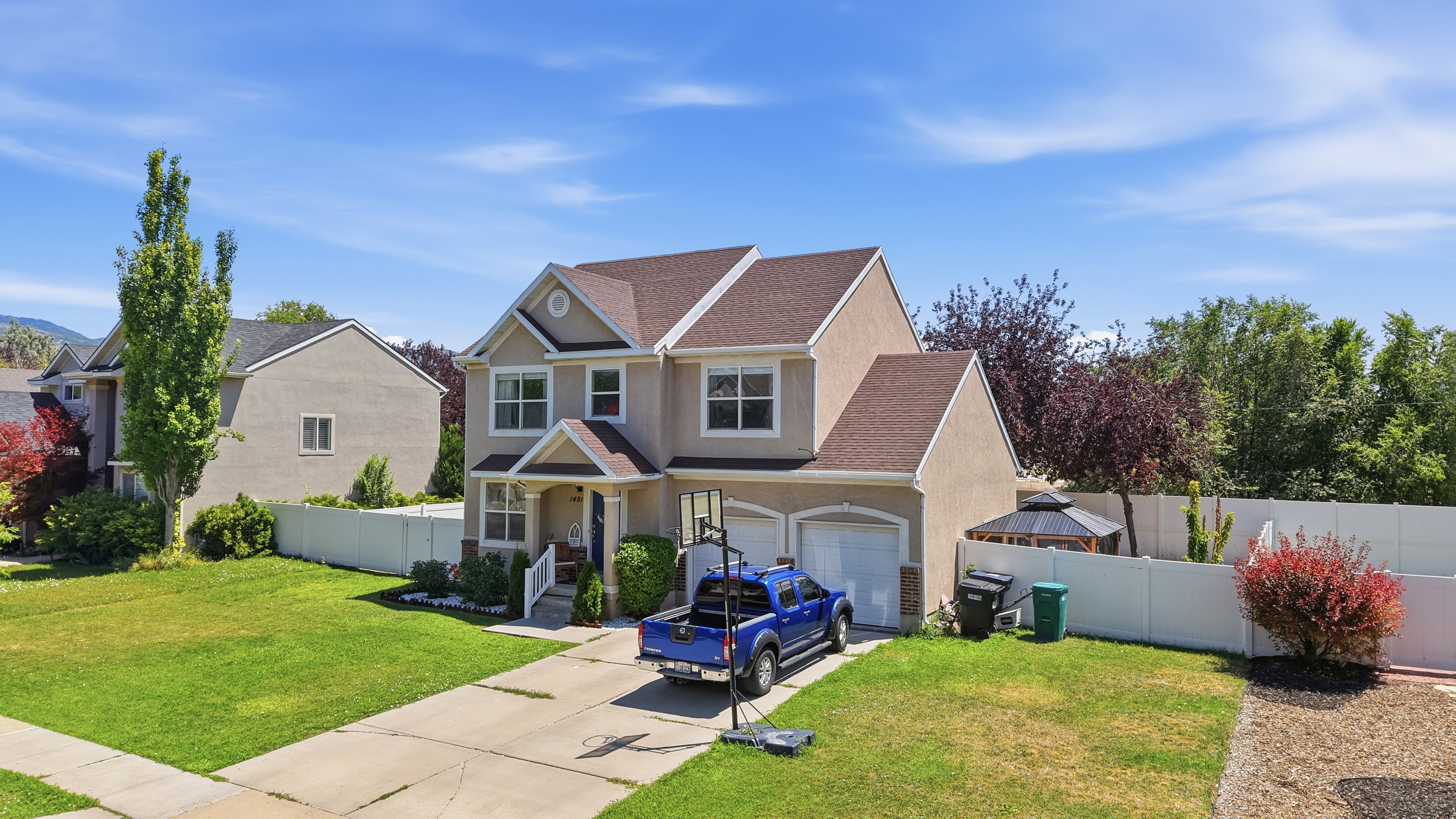 Two-story residence featuring a stucco exterior and gabled roof