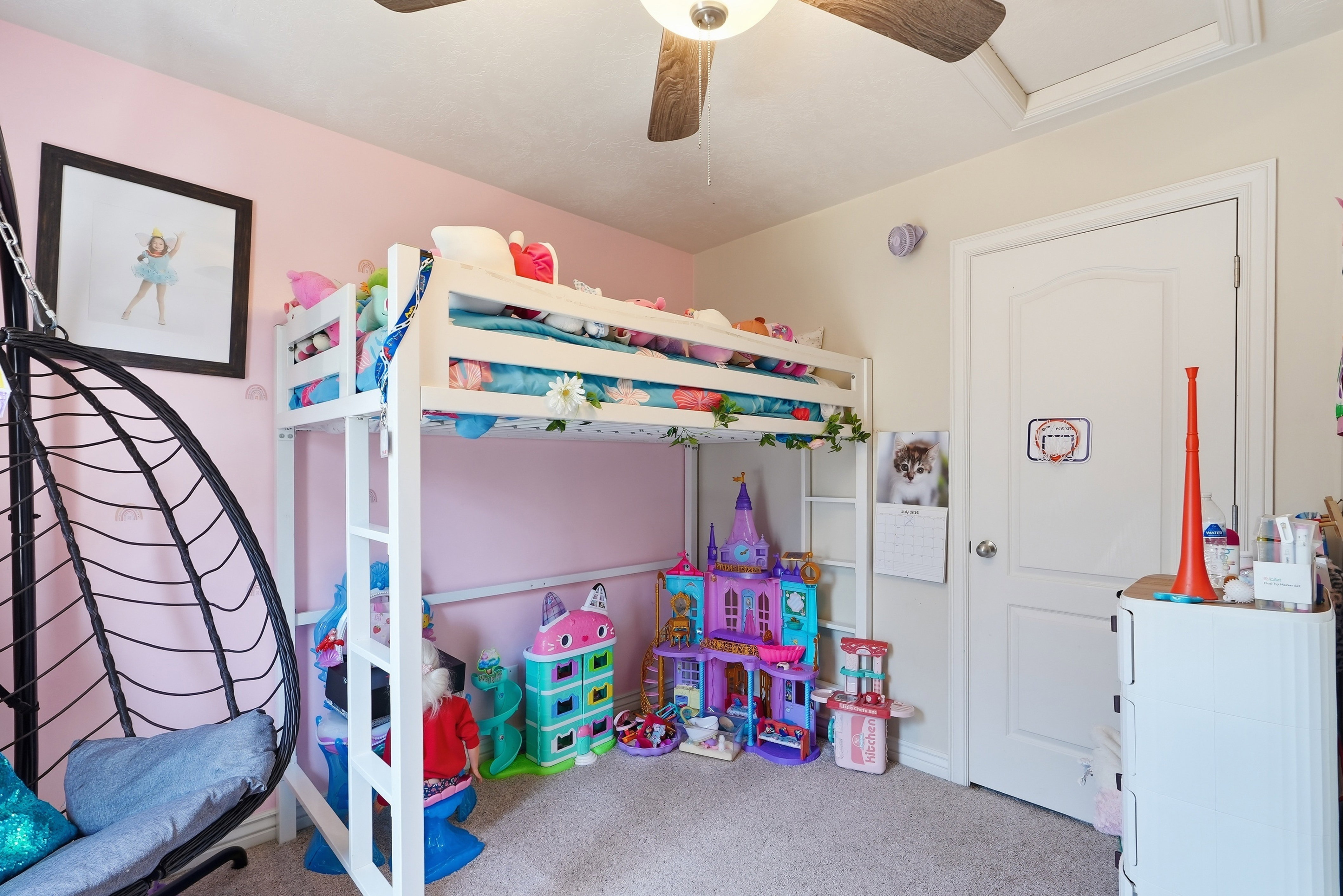 Carpeted room featuring a white interior door with a rounded arch panel, a multi-speed ceiling fan with wood-finish blades, and painted walls