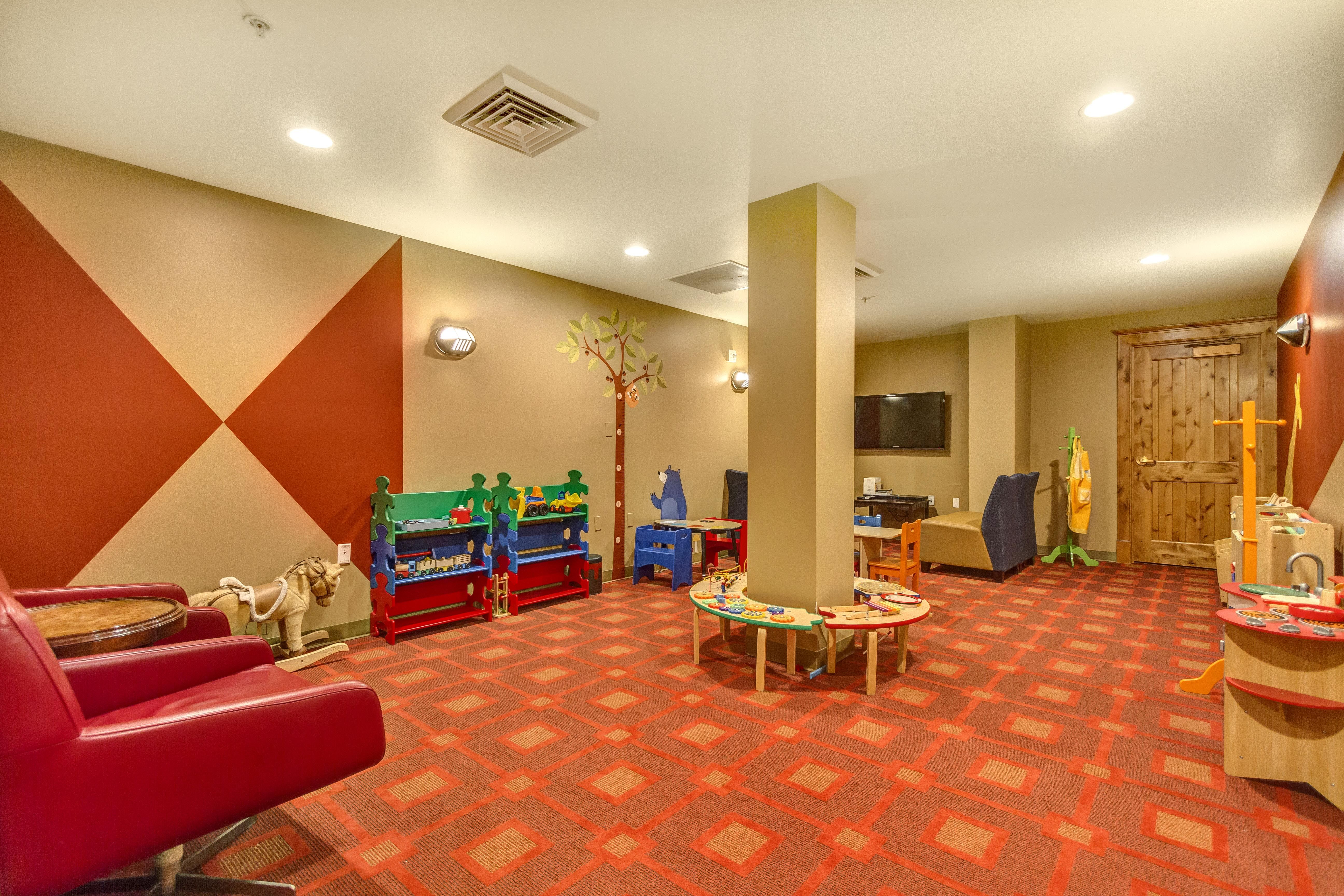 Spacious activity room featuring patterned carpeting, recessed lighting, and accent walls