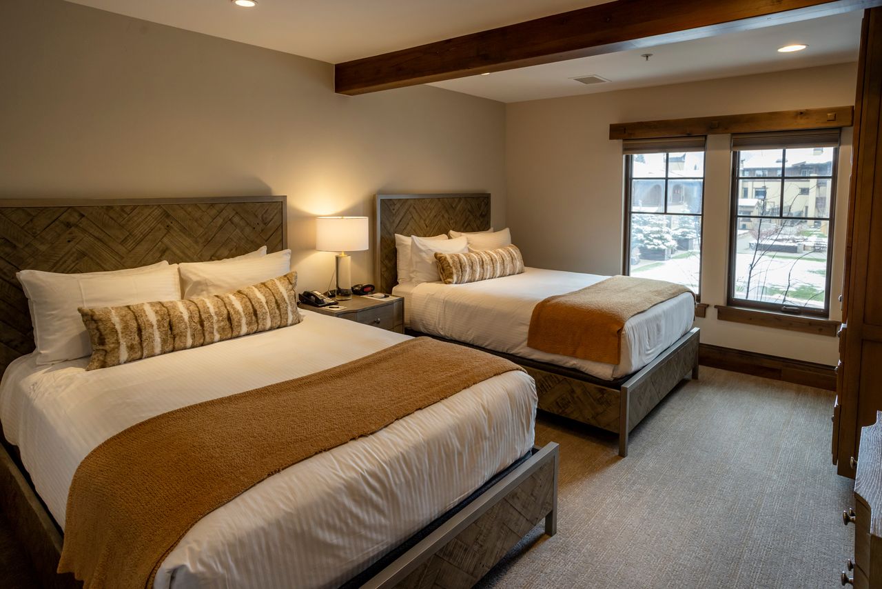 Wood-finish headboards and bed frames define this room