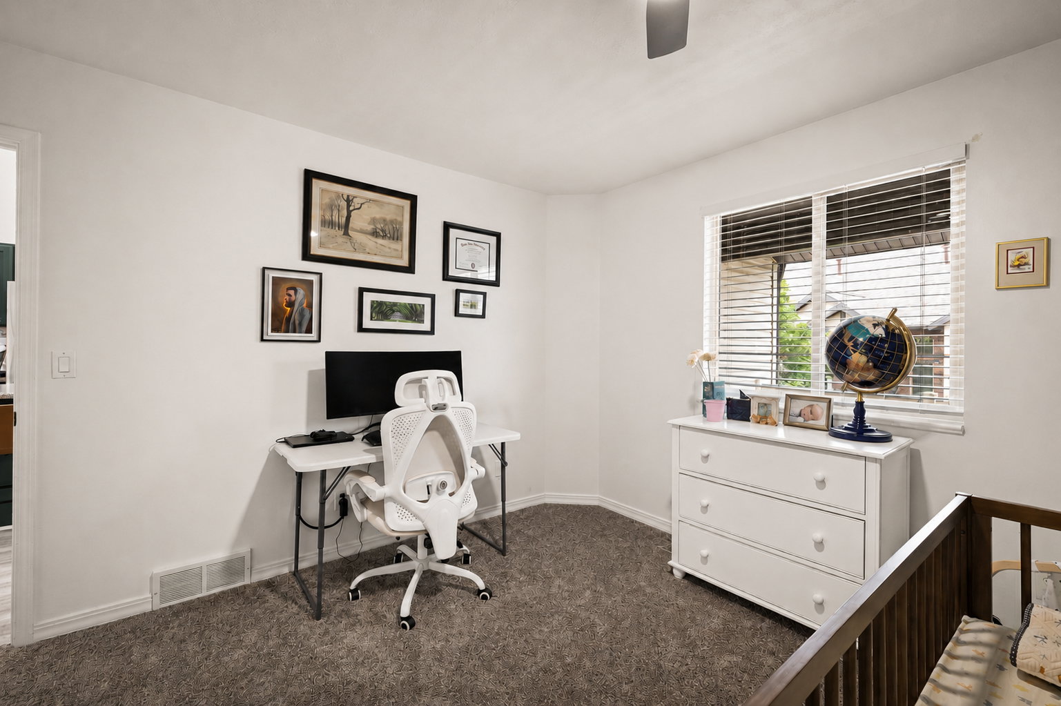 Windowed room with textured carpeting, a white ceiling fan, and white baseboards