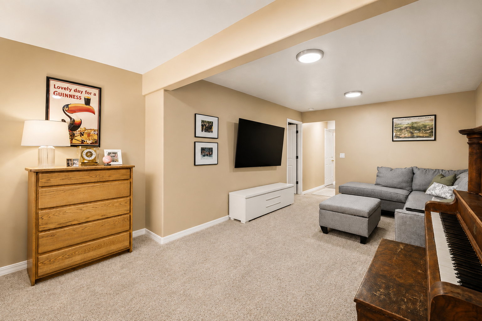 Carpeted room featuring a recessed ceiling beam and neutral wall tones