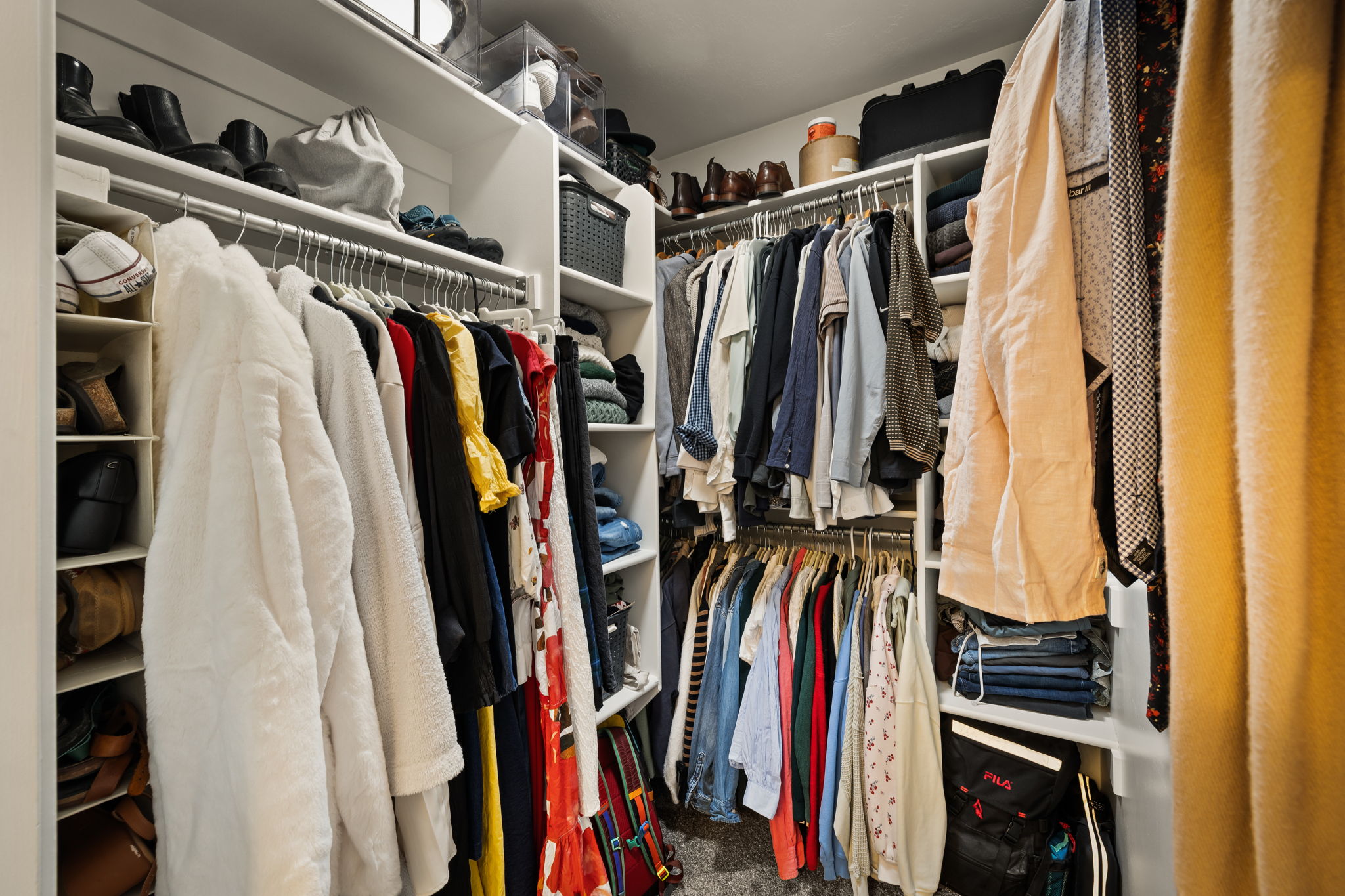 Custom closet system featuring multiple hanging rods, integrated shelving, and dedicated shoe storage