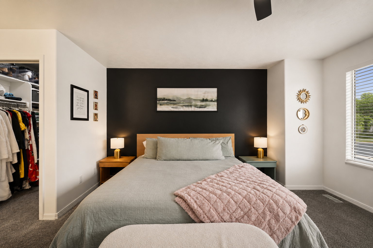 Bedroom with a contrasting accent wall, ceiling fan, and carpeted flooring