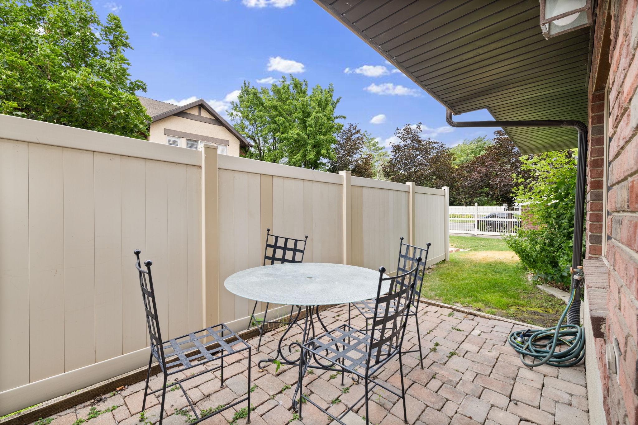 Brick patio with a privacy fence and a modest lawn area