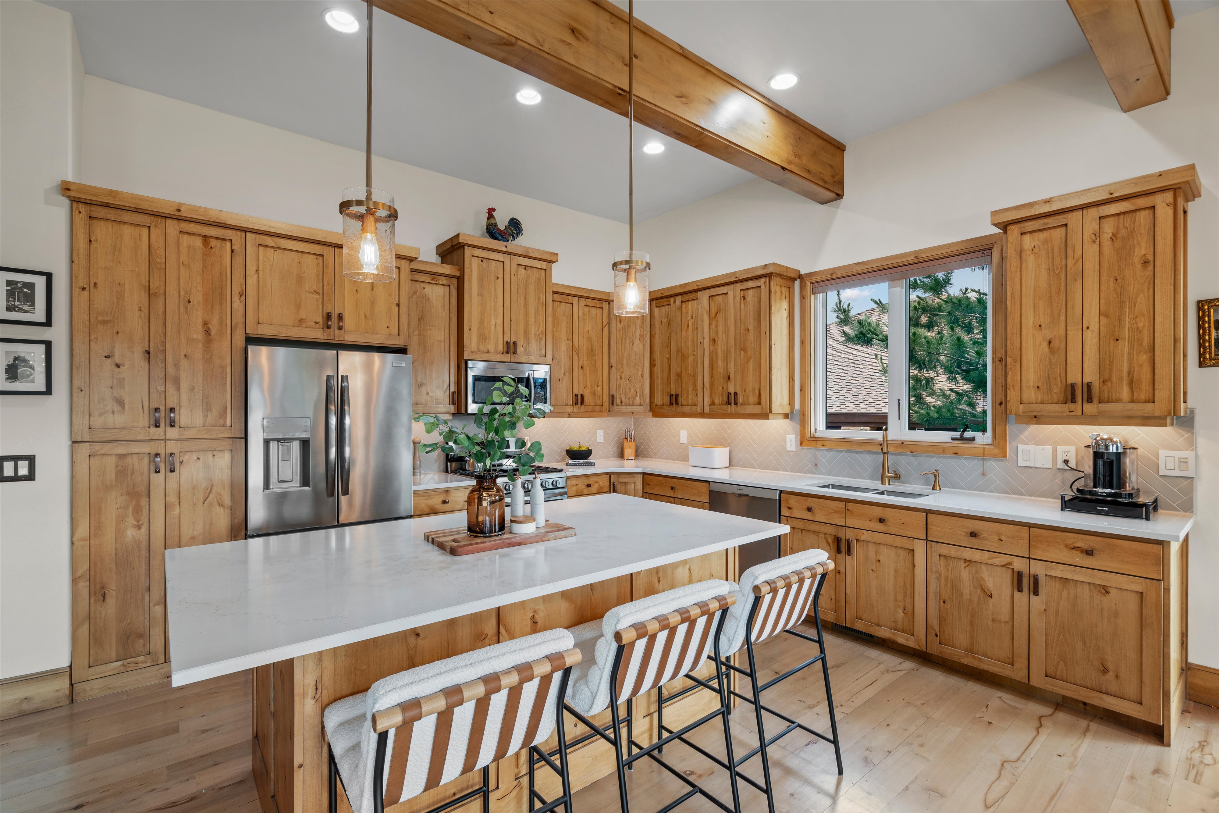 Spacious kitchen featuring extensive wood cabinetry, a large center island with a white countertop, and stainless steel appliances