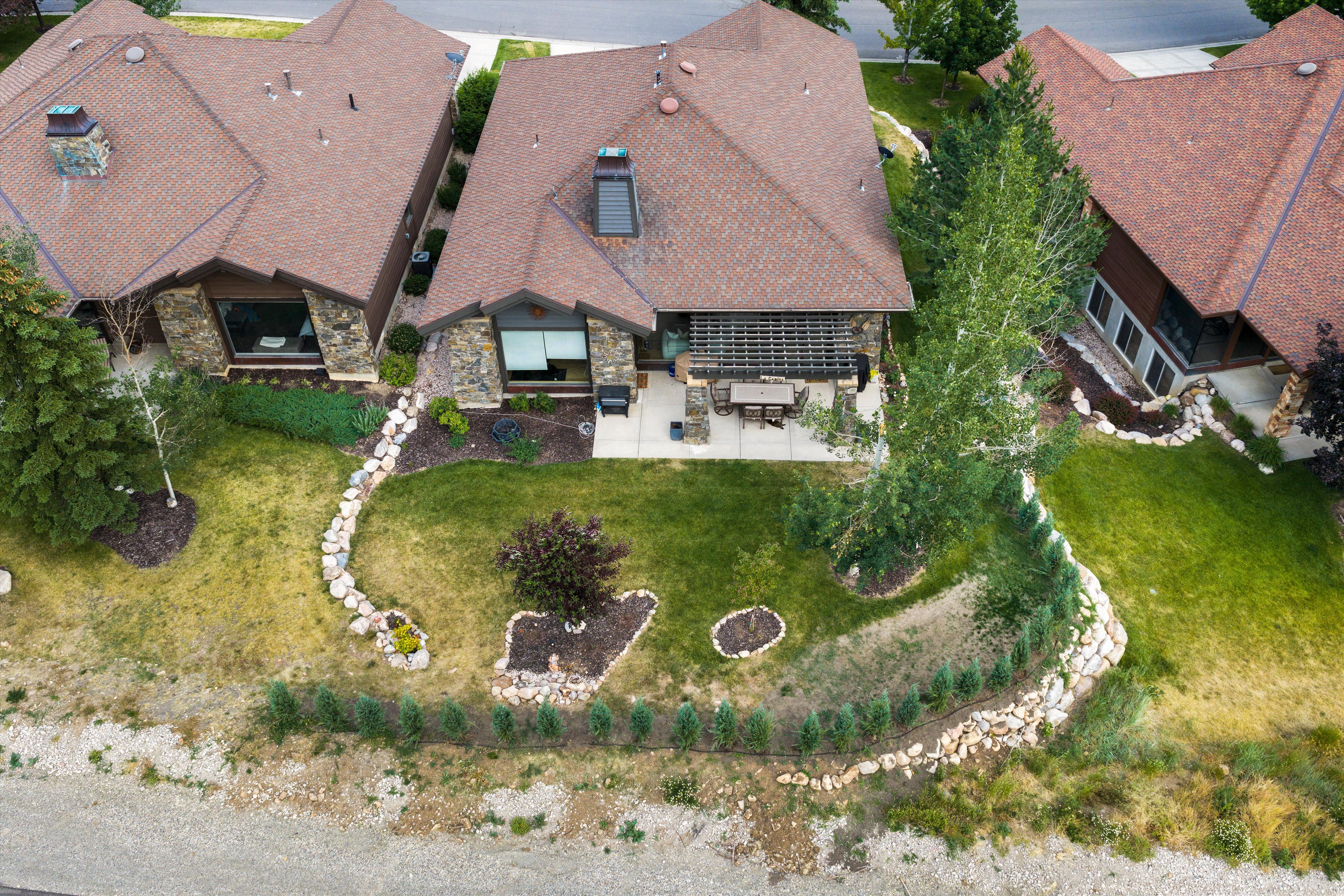 Stone-accented exterior with a brown shingle roof and a skylight