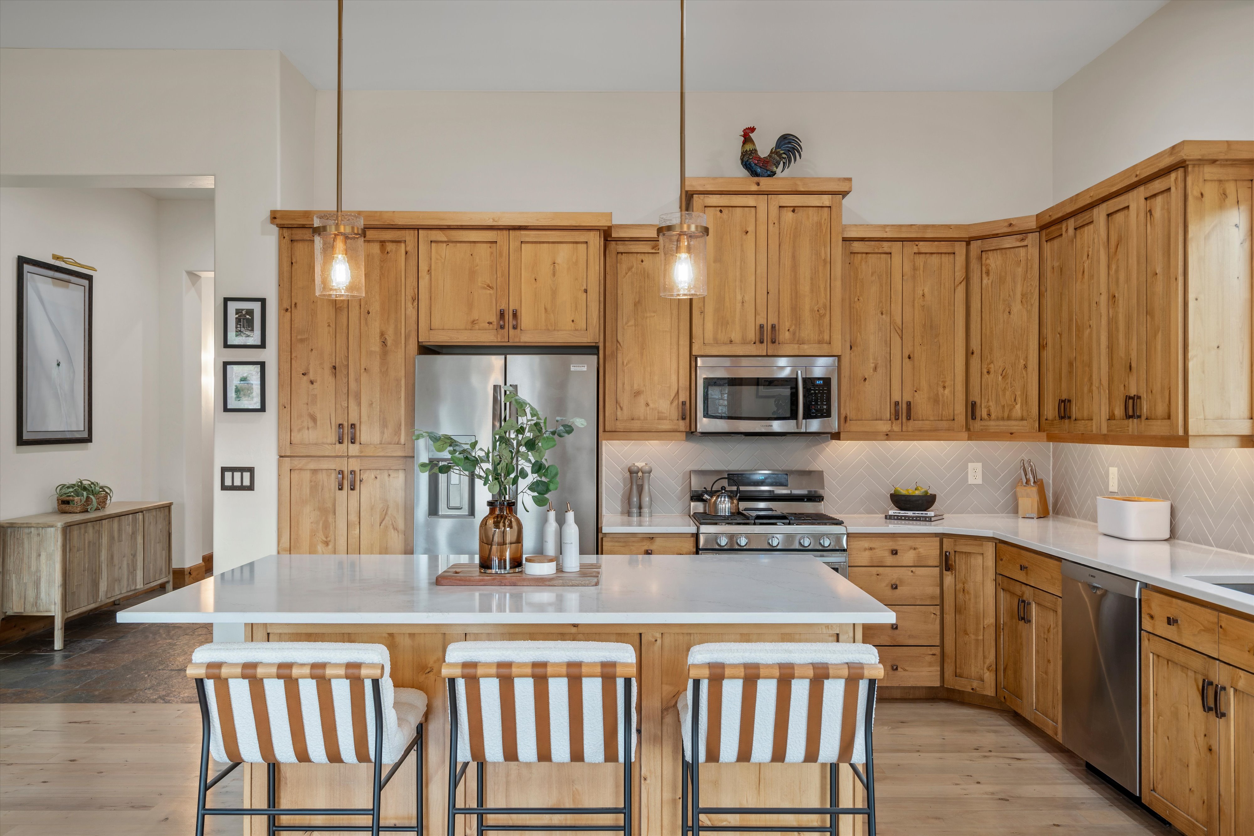 Kitchen featuring natural wood cabinetry, stainless steel appliances, and a central island with a light-toned countertop