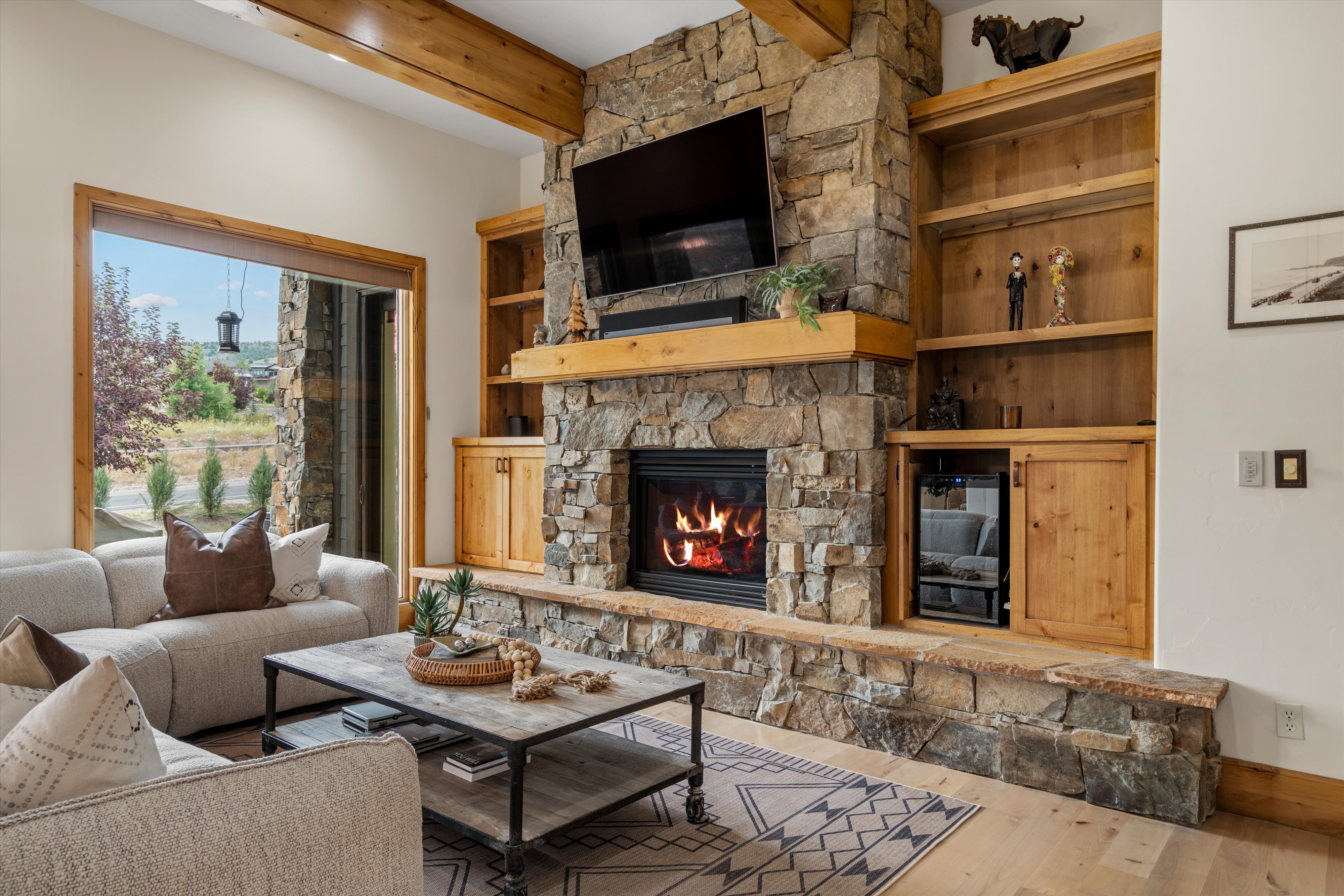 Stone fireplace with an integrated wood-mantle and built-in shelving