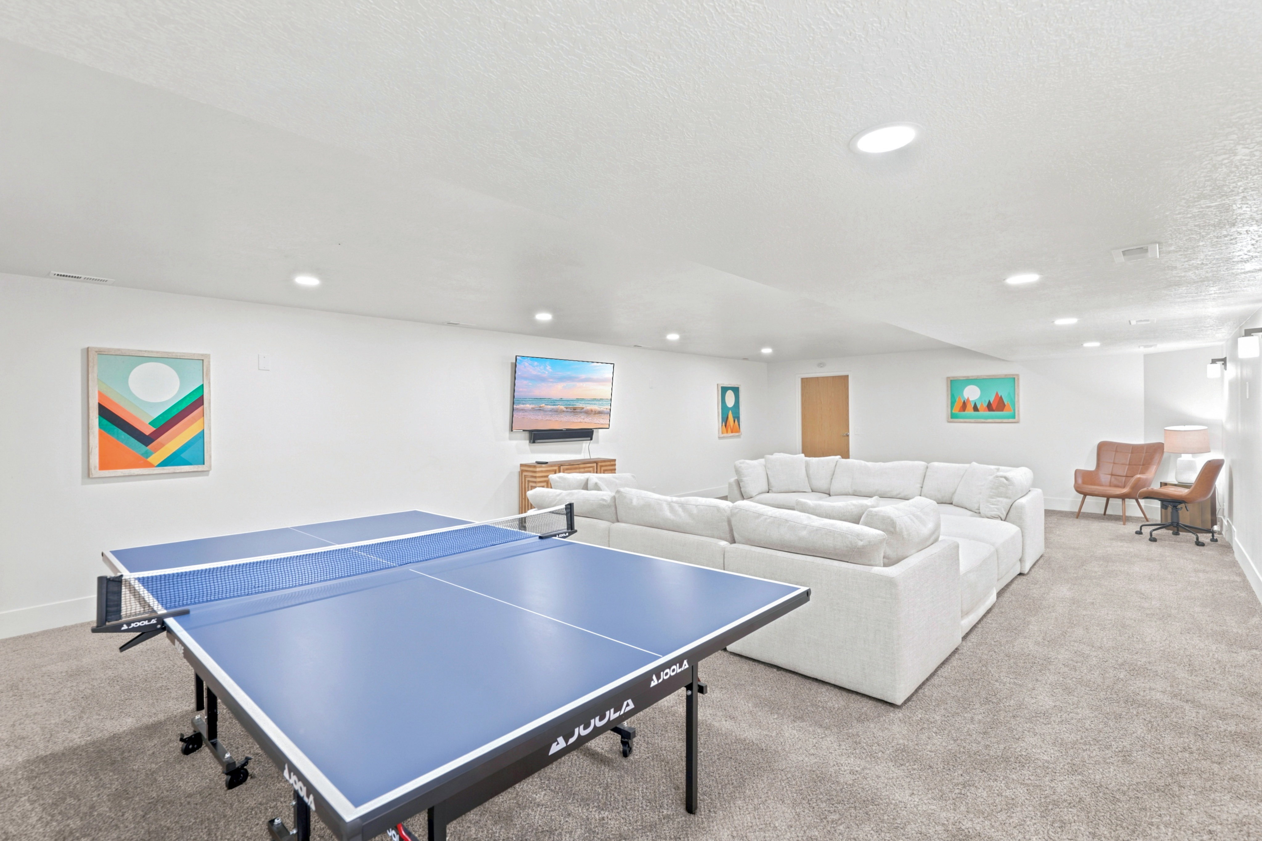 Spacious entertainment area featuring recessed lighting, light-toned carpeting, and white painted walls