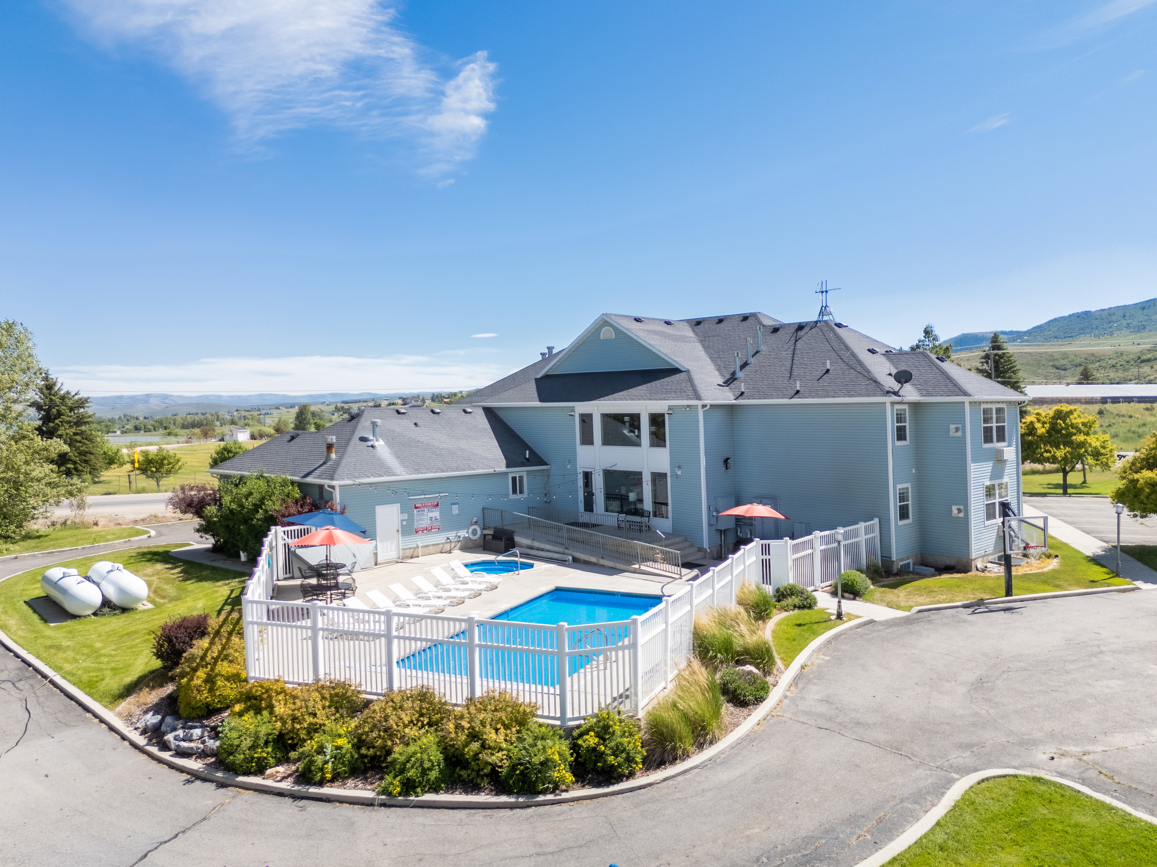 Exterior property featuring a swimming pool, hot tub, and surrounding white fence