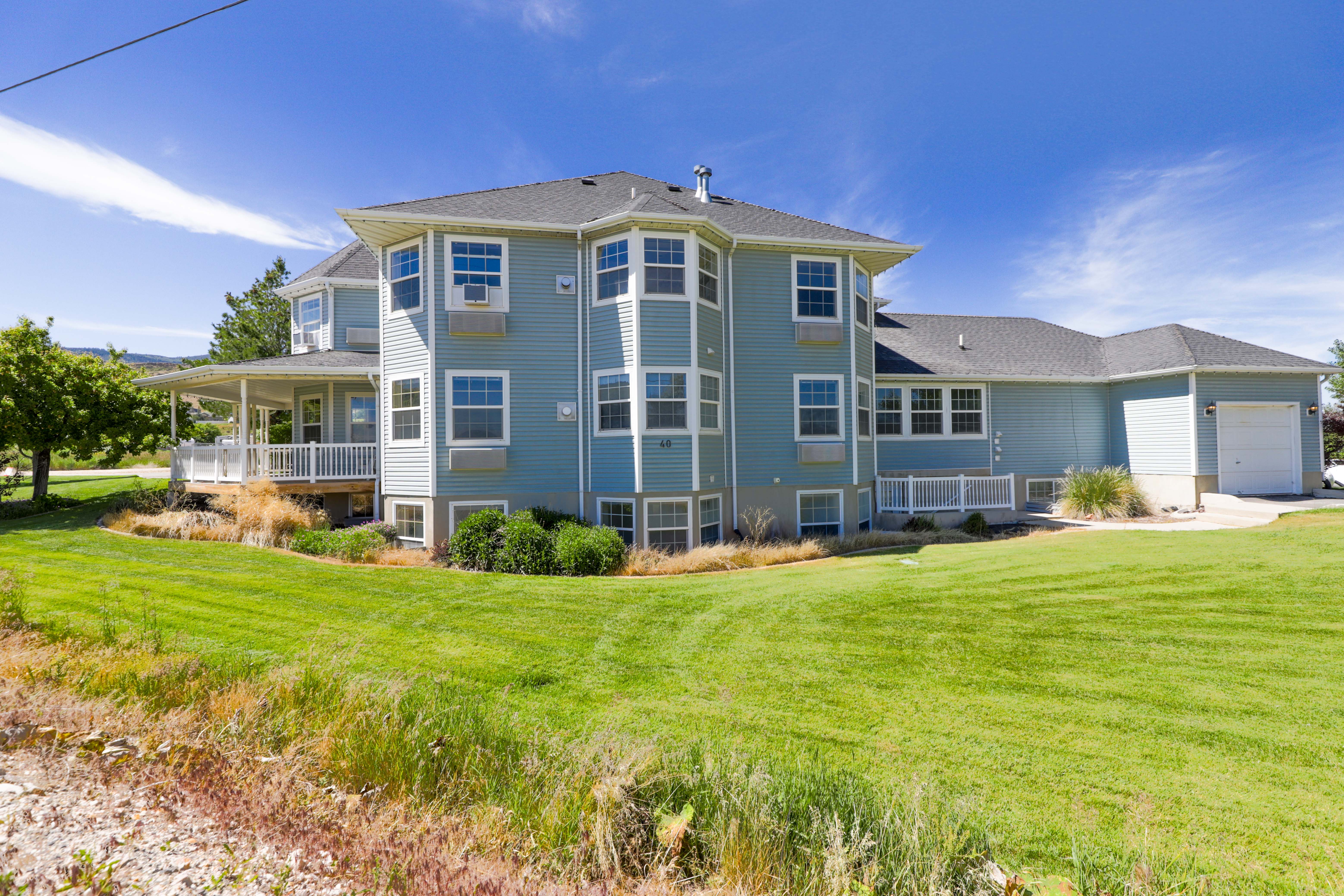 Two-story residence with light blue siding and a dark shingle roof
