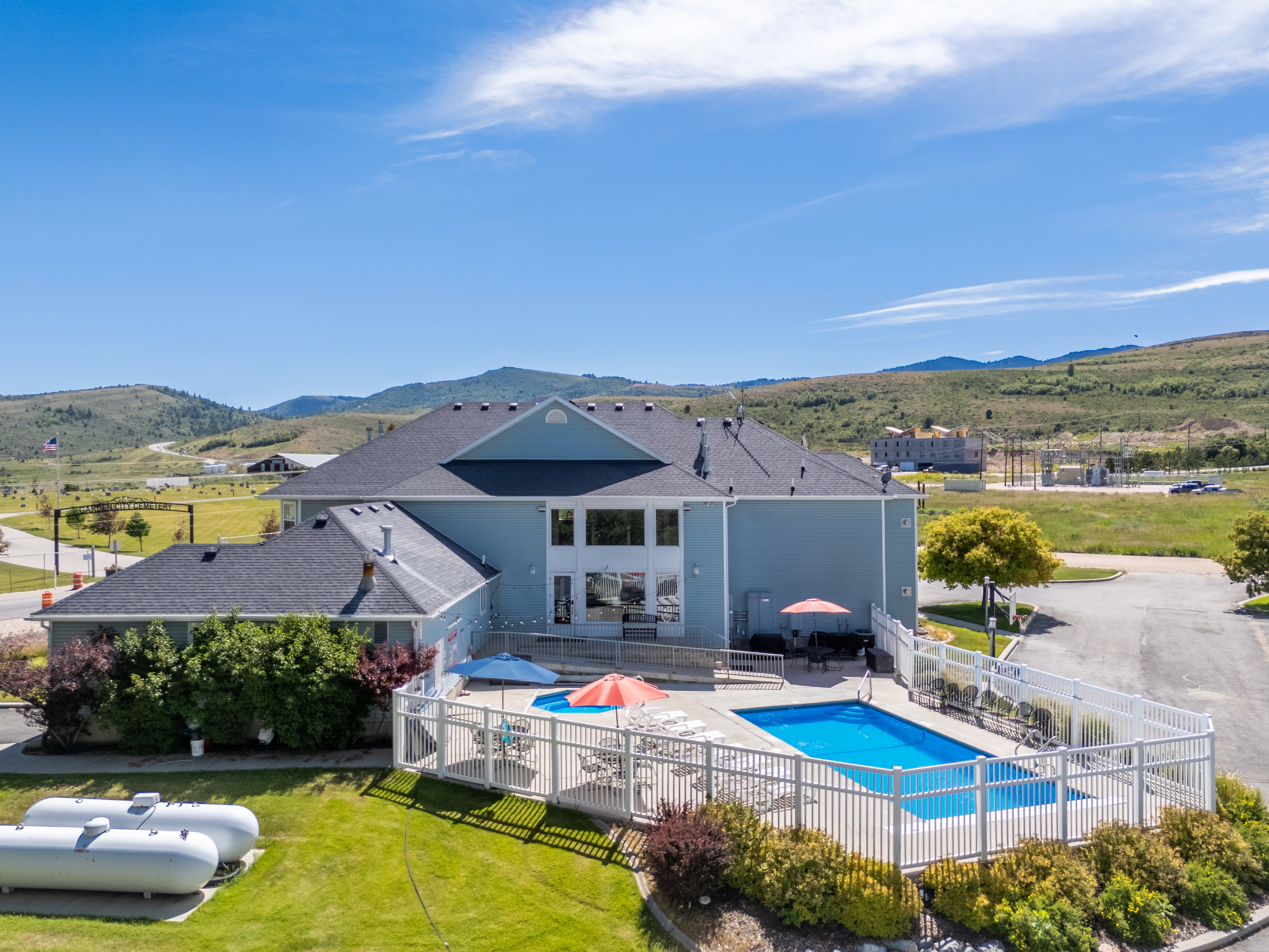 Expansive exterior showcasing a recreational pool area, a surrounding white picket fence, and broad windows