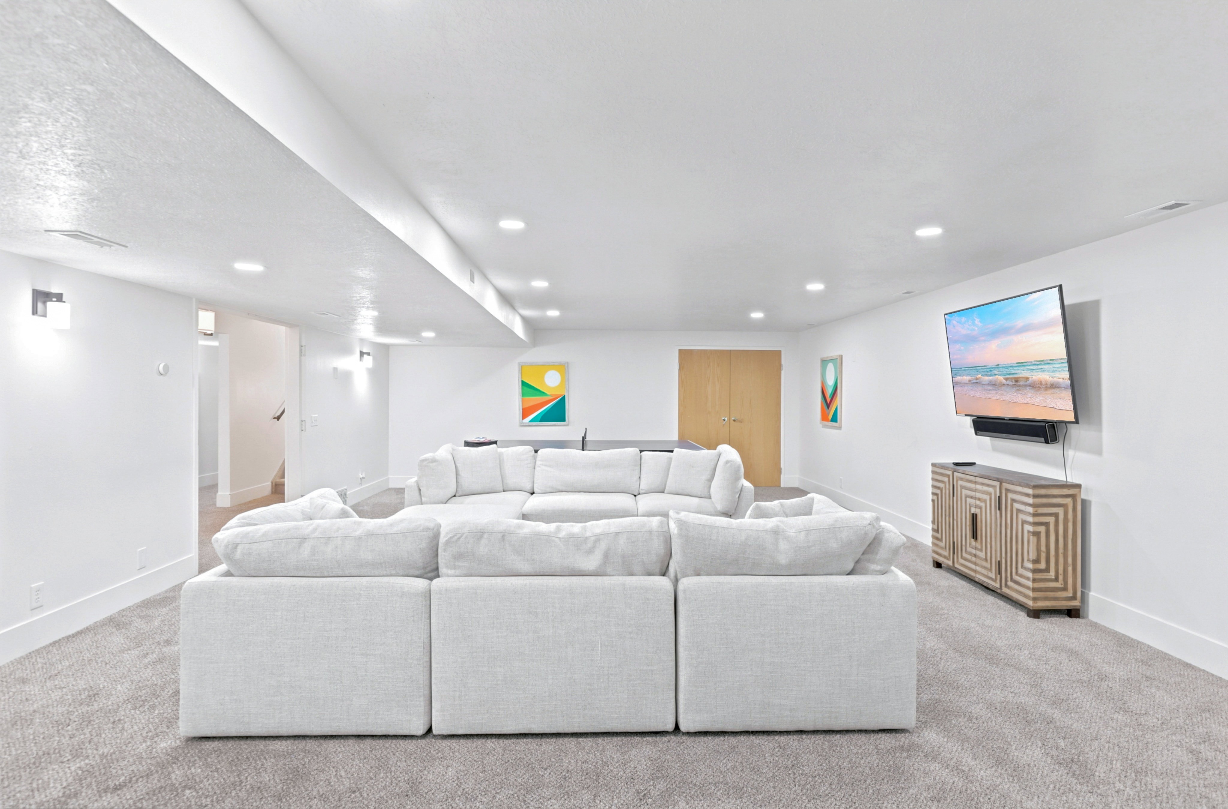 Spacious room featuring light gray carpeting and white walls