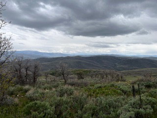 Expansive landscape featuring rolling hills and distant mountains