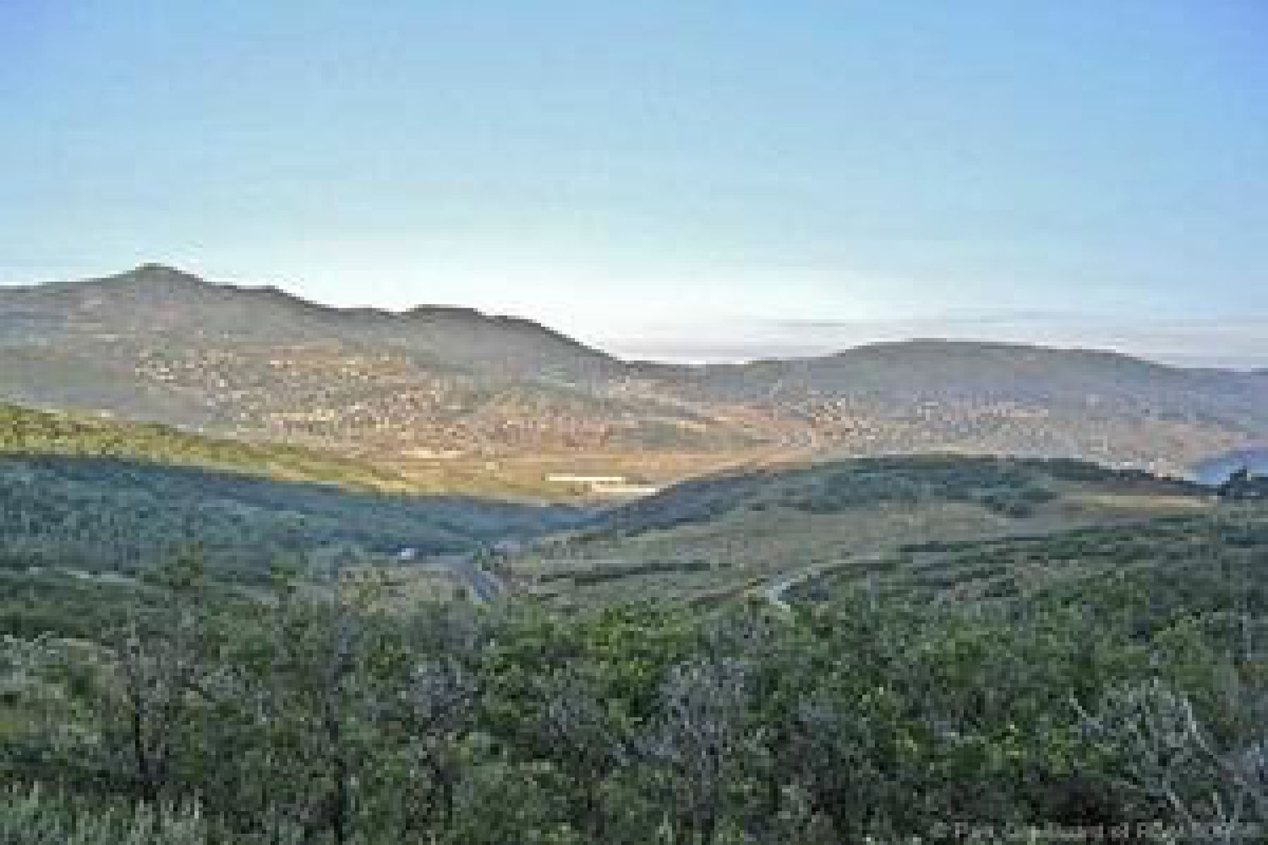 Expansive mountain landscape featuring varied terrain and distant community lights